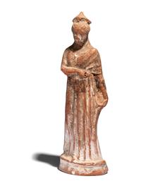 A Greek Terracotta Draped Female Figure with a Pilos
