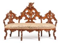 A Black Forest Carved Walnut Settee Height 47 1/2 x width 71 x depth 26 inches. — 19TH CENTURY