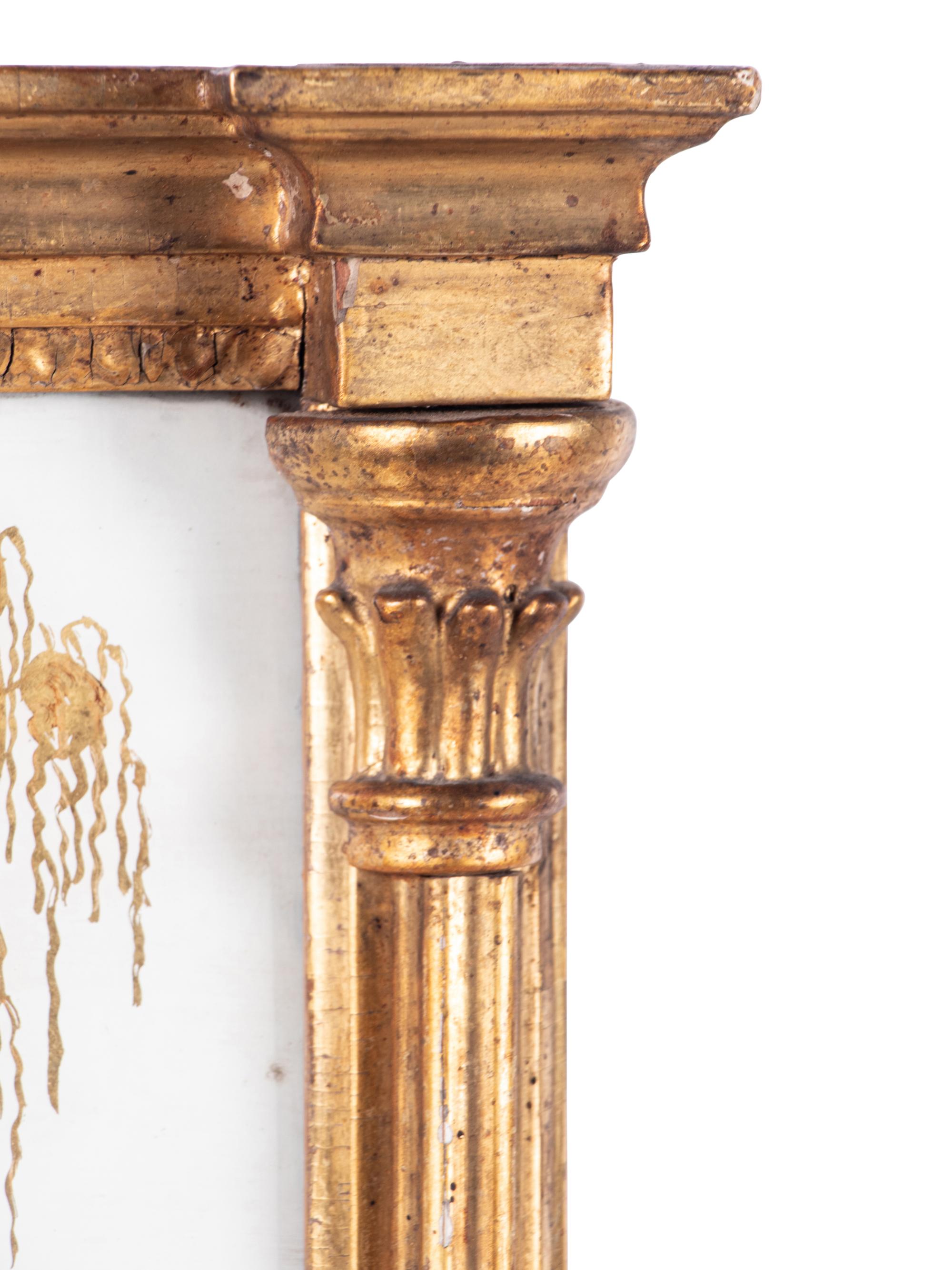 A Classical Giltwood and Eglomise Panel Inset Looking Glass