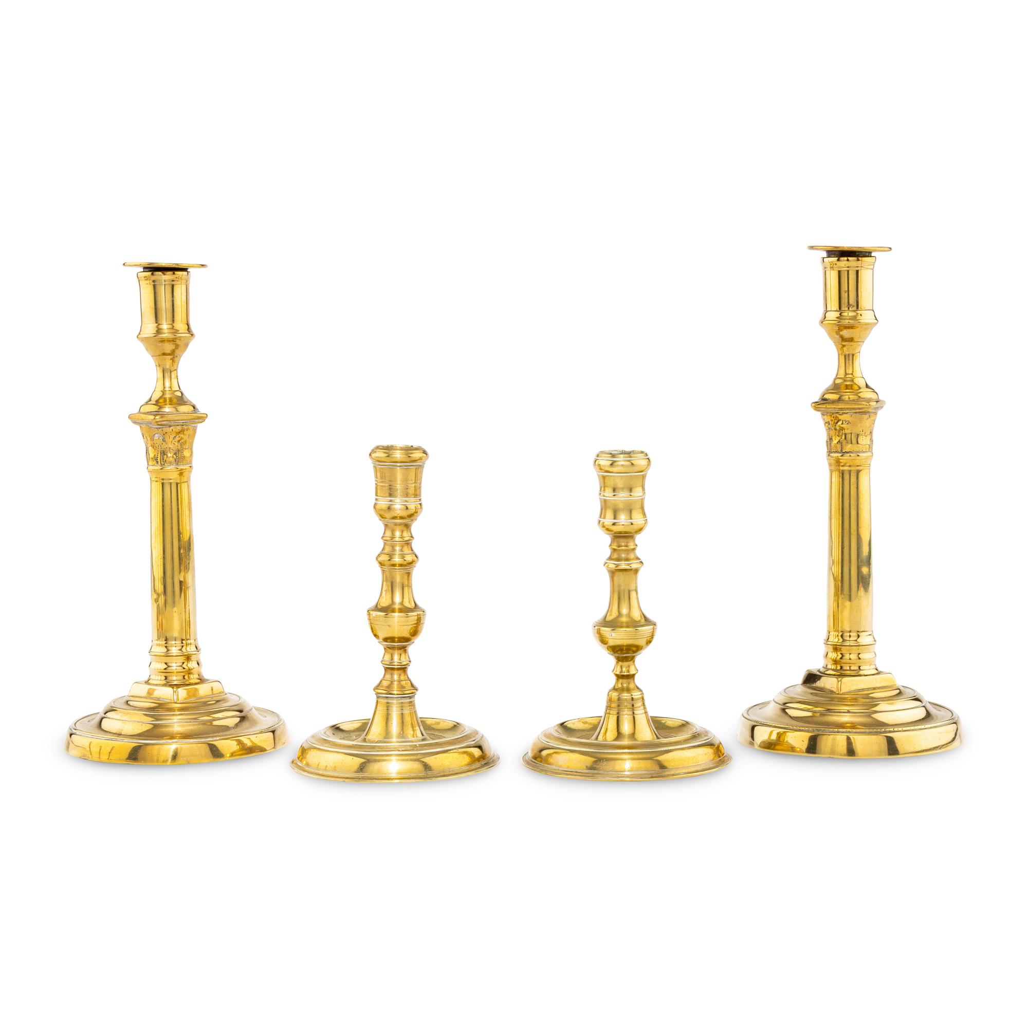A Collection of Two Pairs of Brass Candlesticks