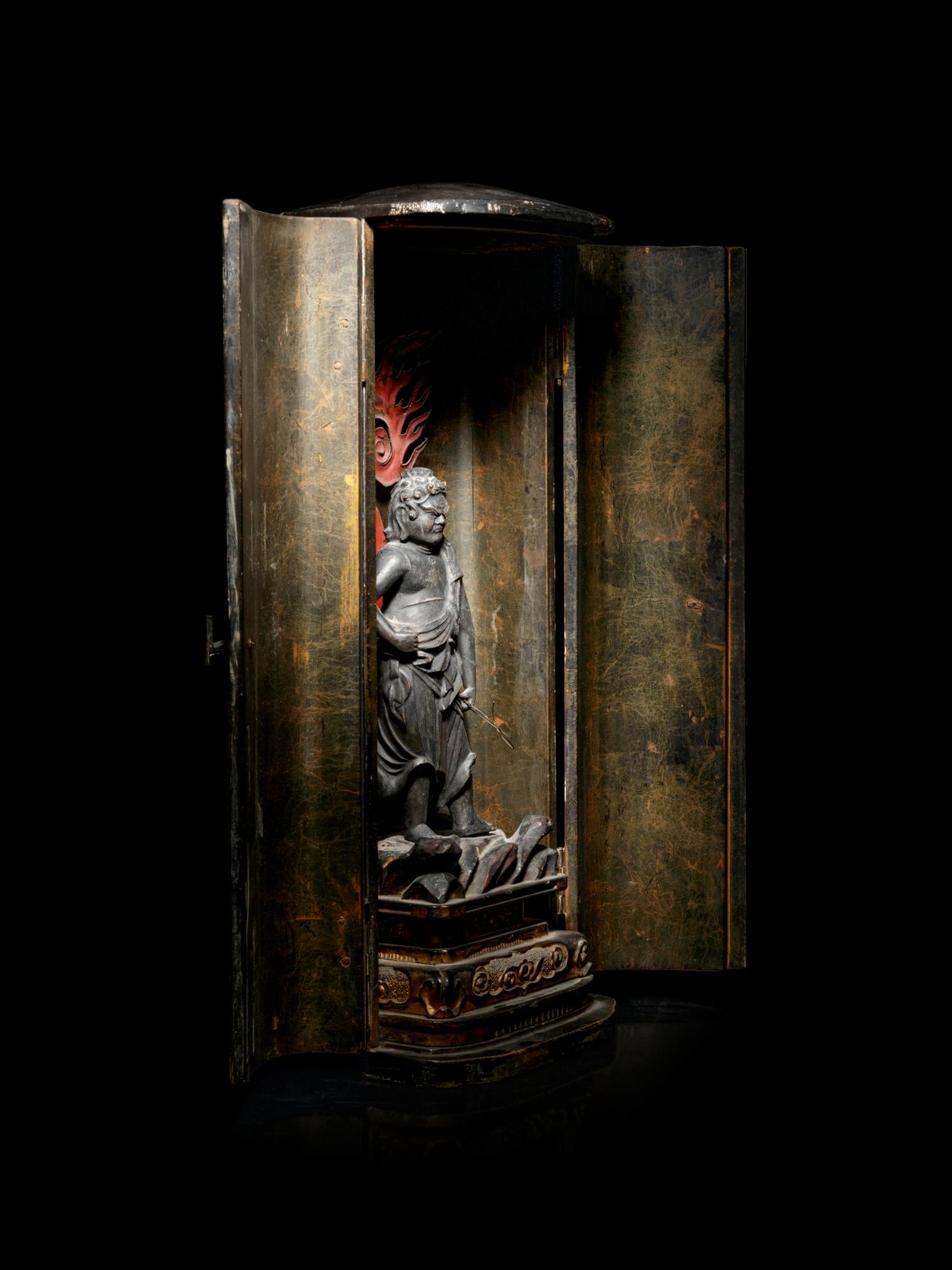A Black Lacquered Shrine with a Polychrome and Black Painted Wood Figure of a Guardian