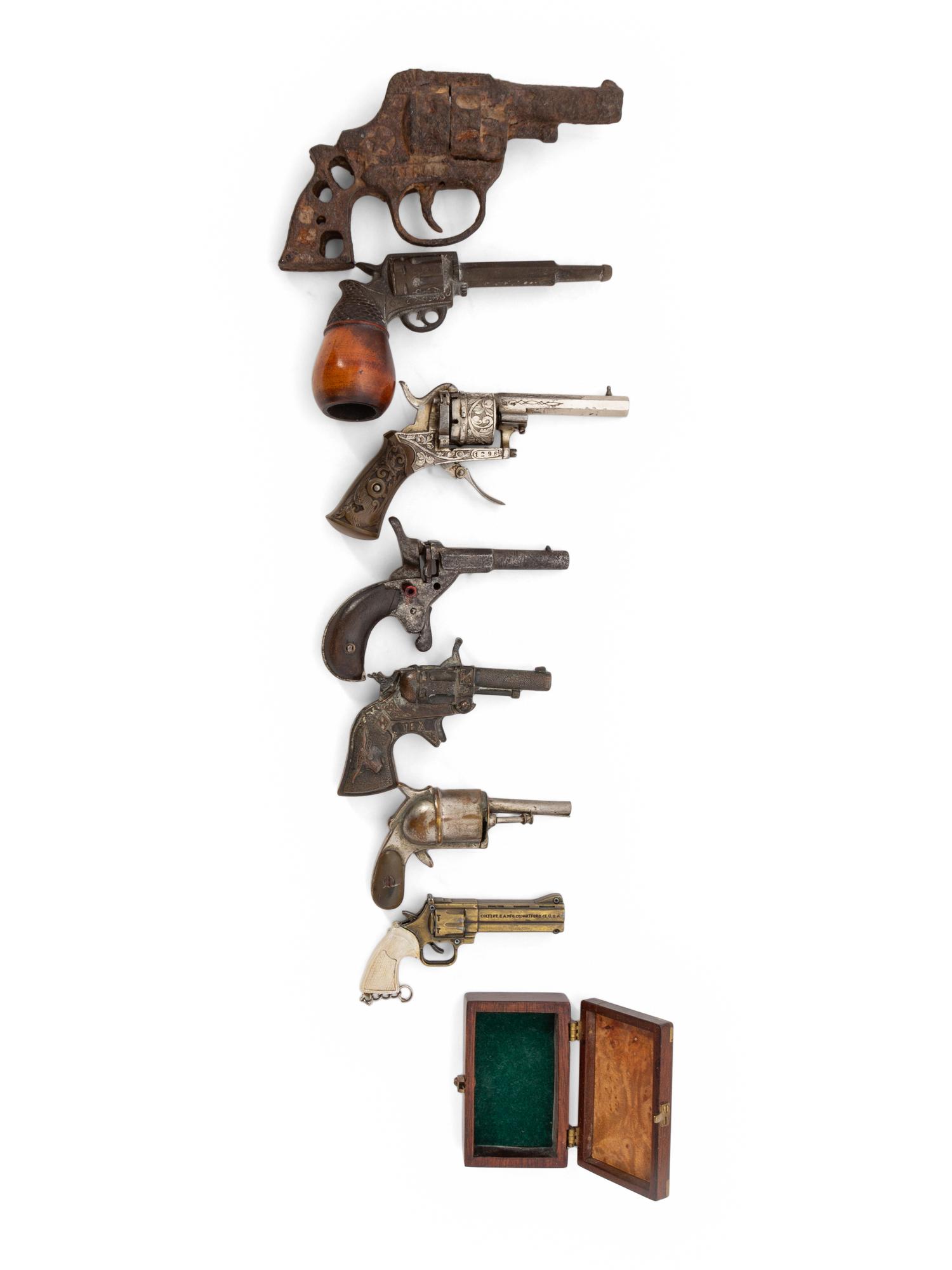 A Group of Eight Miniature Firearms Related Accoutrements