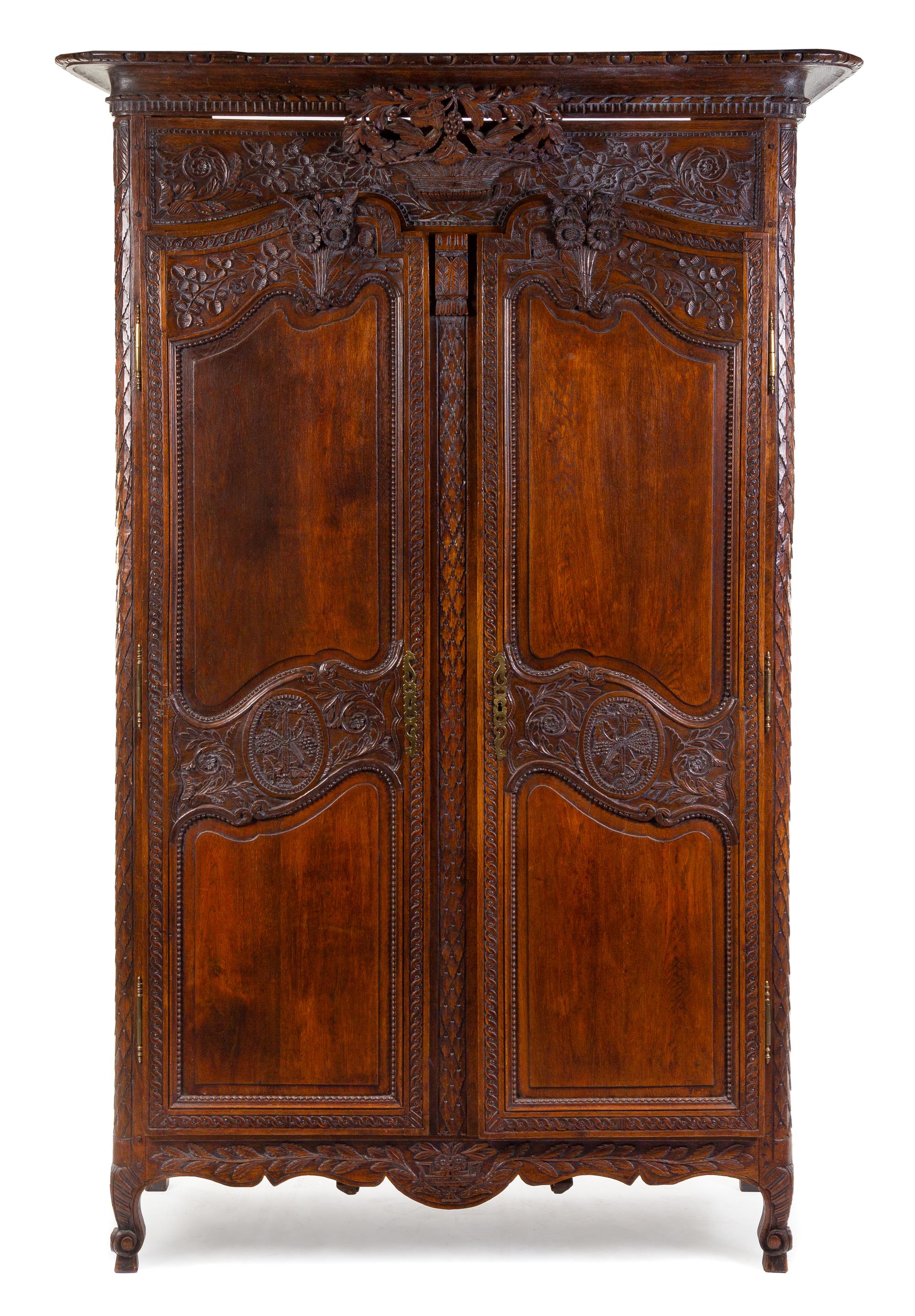 A French Provincial Carved Walnut Armoire Height 87 3/4 x width 51 x depth 19 1/2 inches. — PROBABLY BRITTANY, EARLY 19TH CENTURY