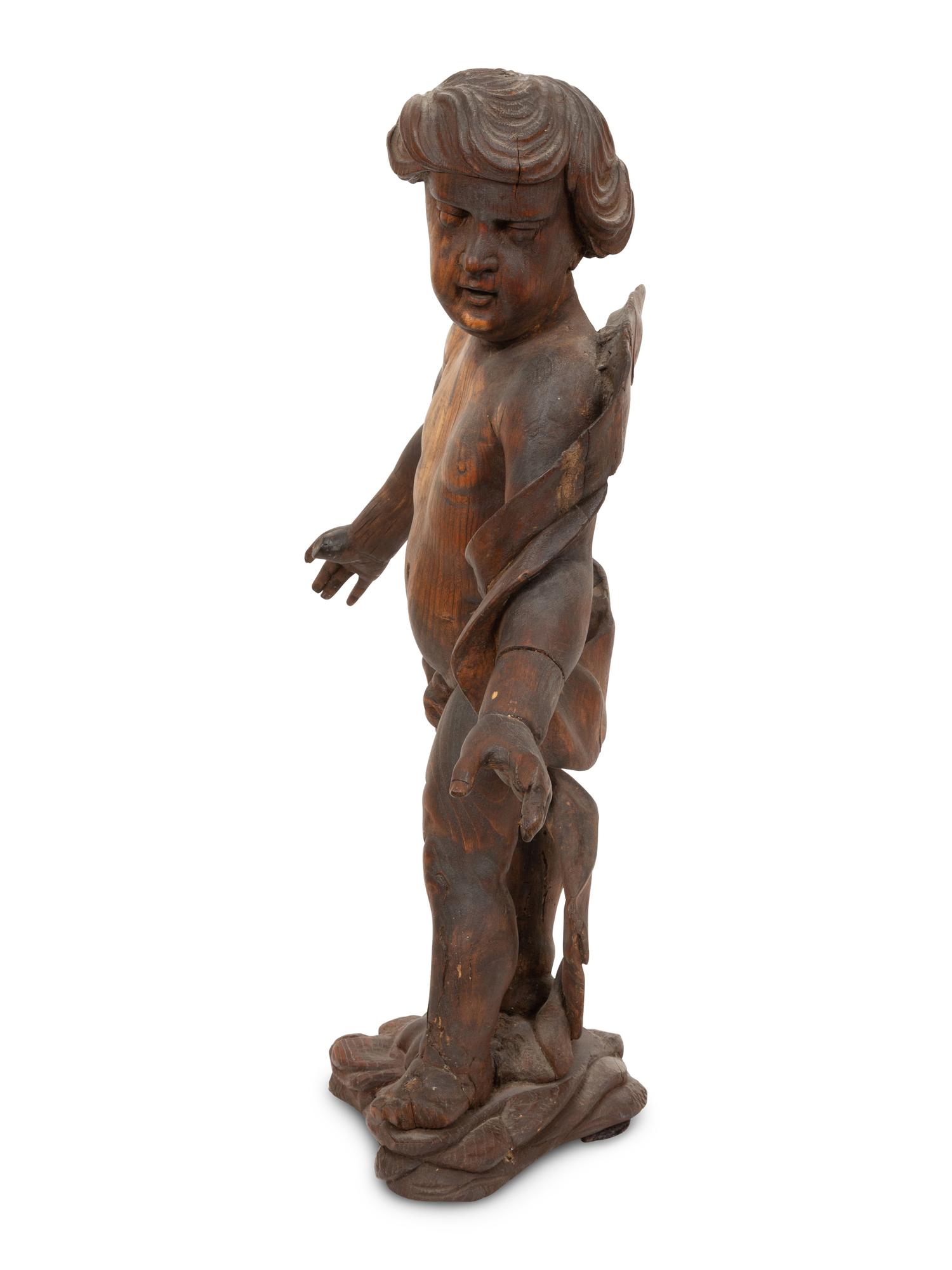 An Italian Carved Walnut Figure of Putto
