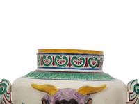 A Pair of Italian Glazed Ceramic Urns Decorated with Horned Masks and Paw Feet