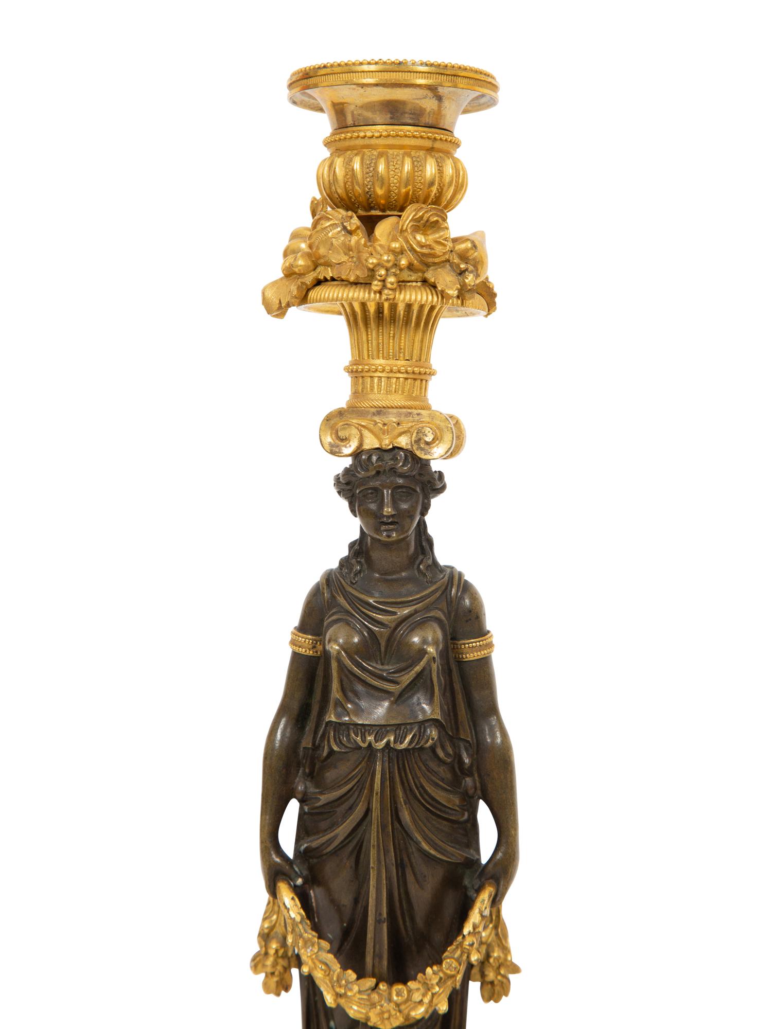 A Pair of French Gilt and Patinated Bronze Figural Candlesticks