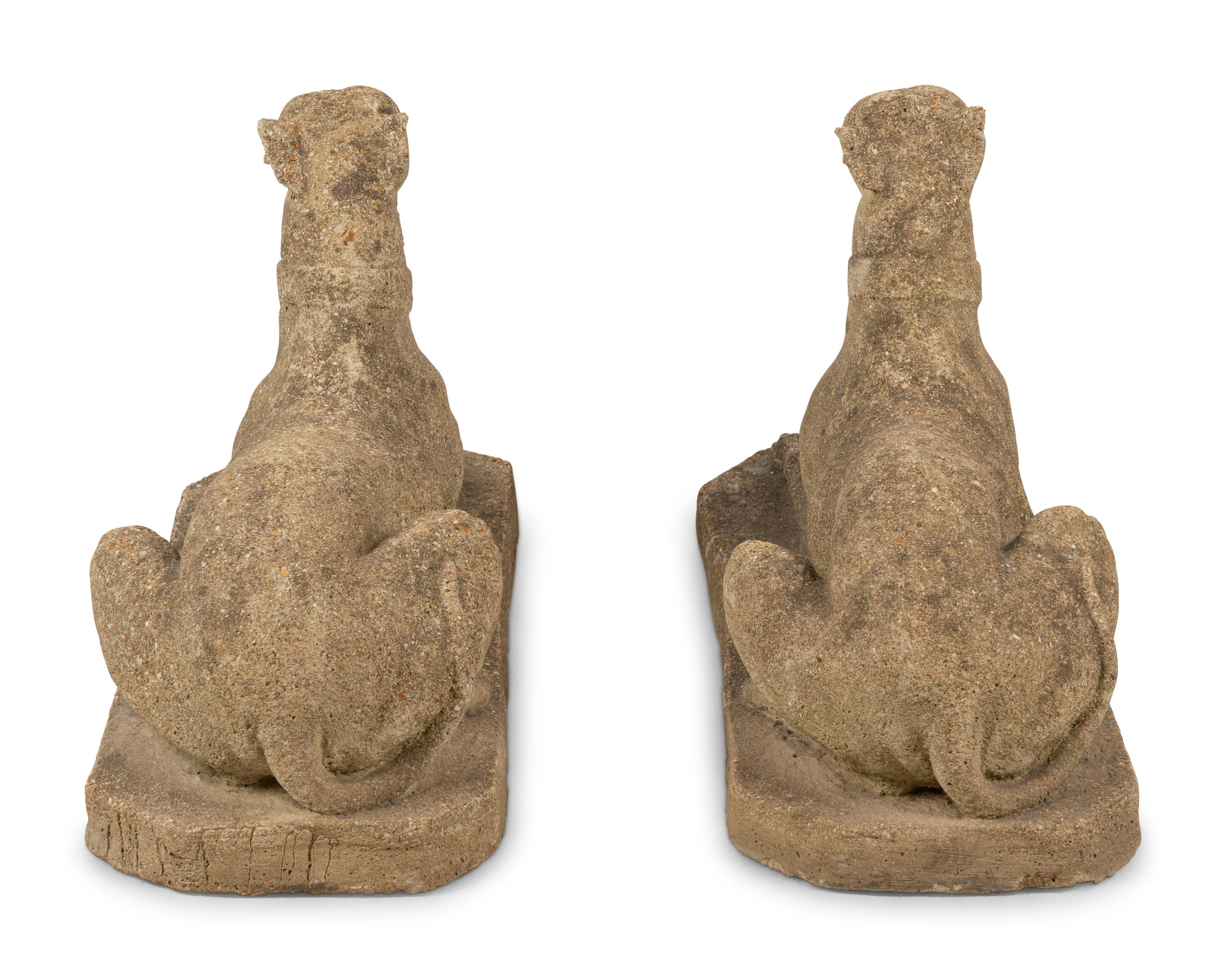 A Pair of Cast Stone Models of Recumbent Dogs
