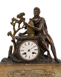 An Empire Style Gilt and Patinated Bronze Figural Mantel Clock