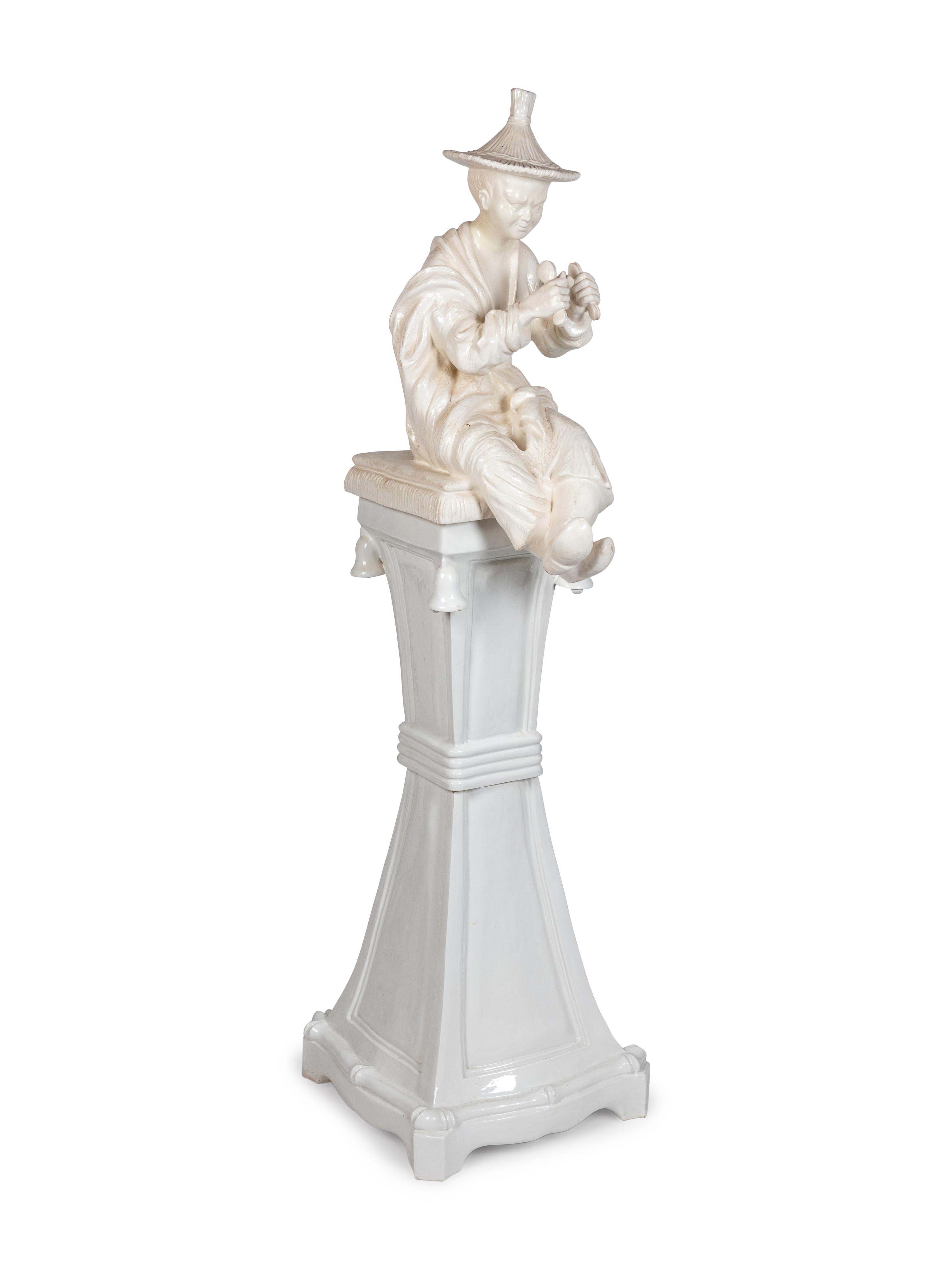 A Continental Blanc de Chine Figure of a Seated Chinese Man on a Pedestal