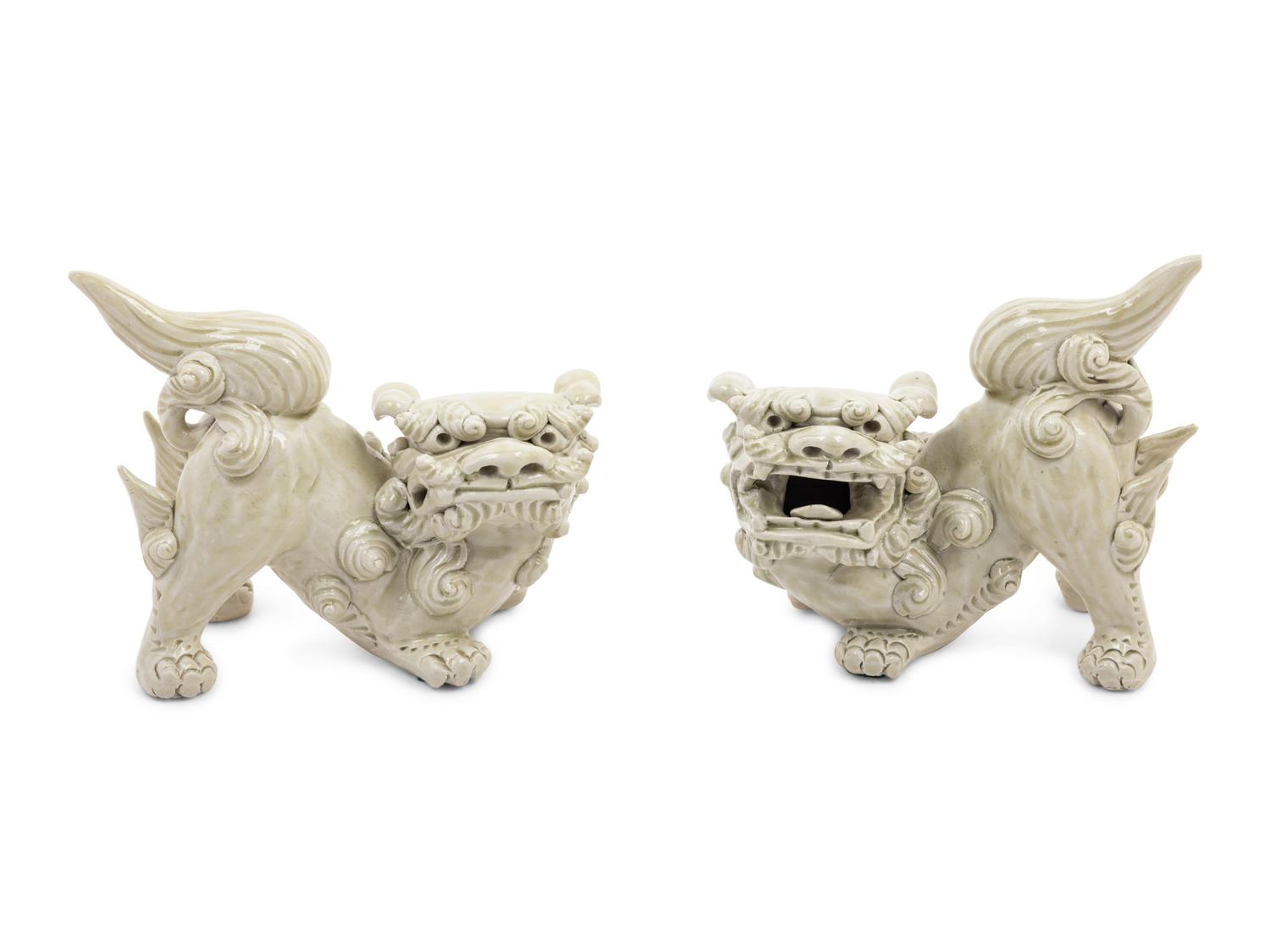 A Pair of Chinese White Glazed Porcelain Figures of Fu Lions