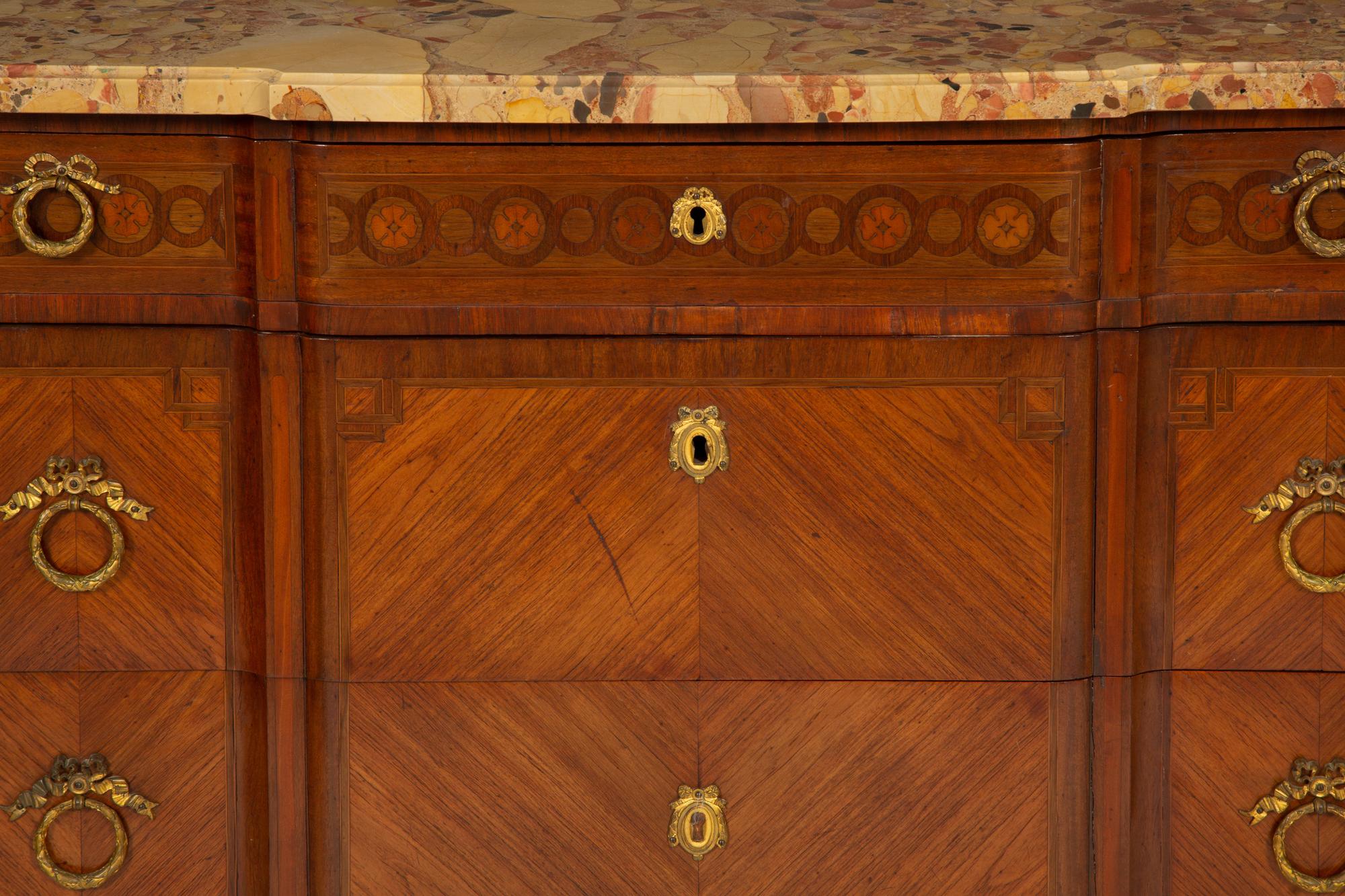 A French Gilt Metal Mounted Mahogany and Kingwood Marquetry Marble-Top Commode