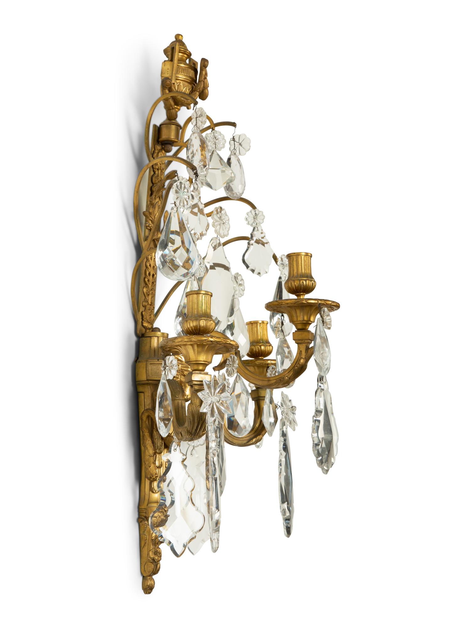 A Pair of Louis XVI Style Gilt Bronze and Cut Glass Three-Light Sconces