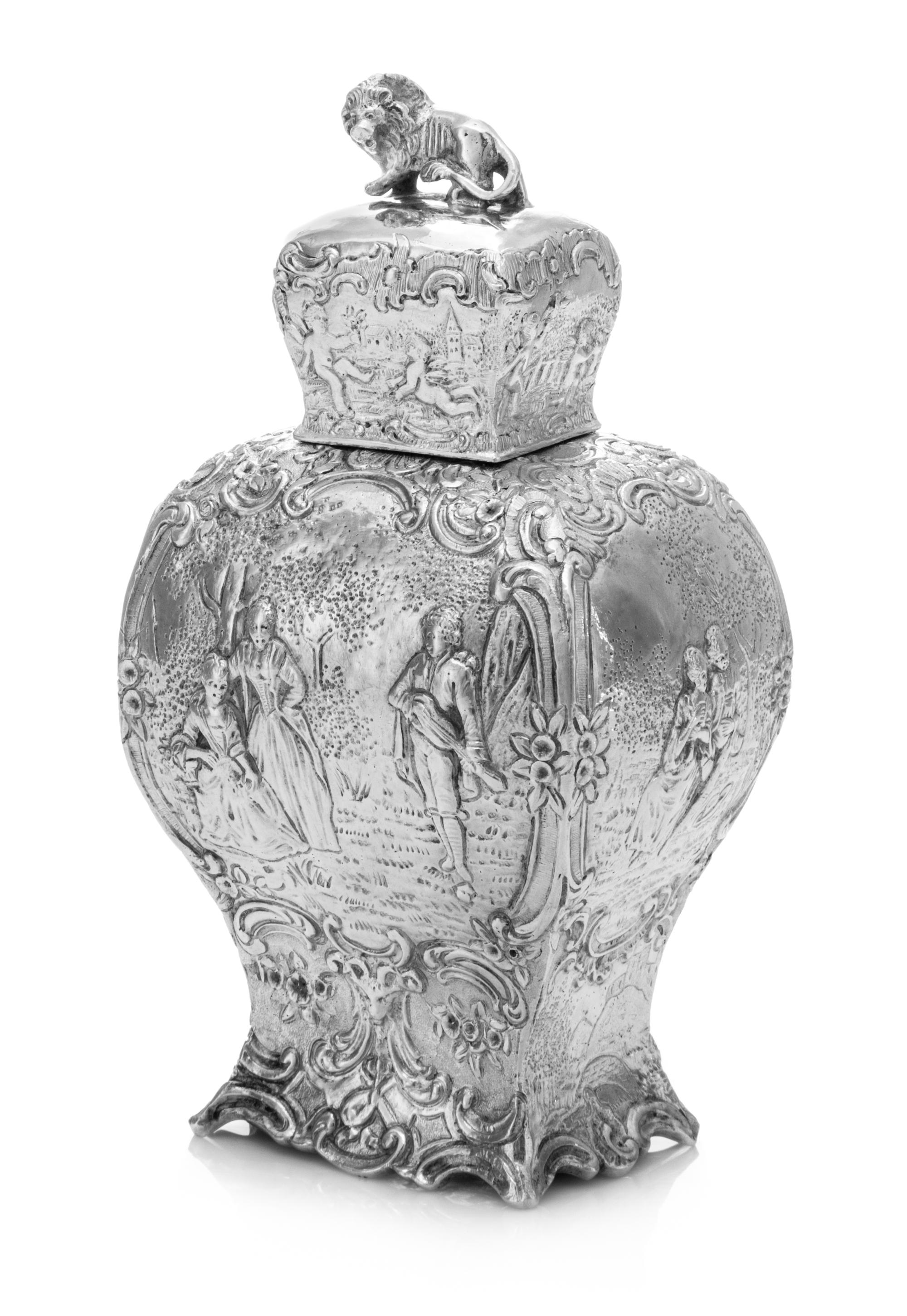 A German Silver Tea Caddy, Wolf & Knell, Hanau, Late 19th/Early 20th Century, of baluster form with a lion finial, the body depicting c