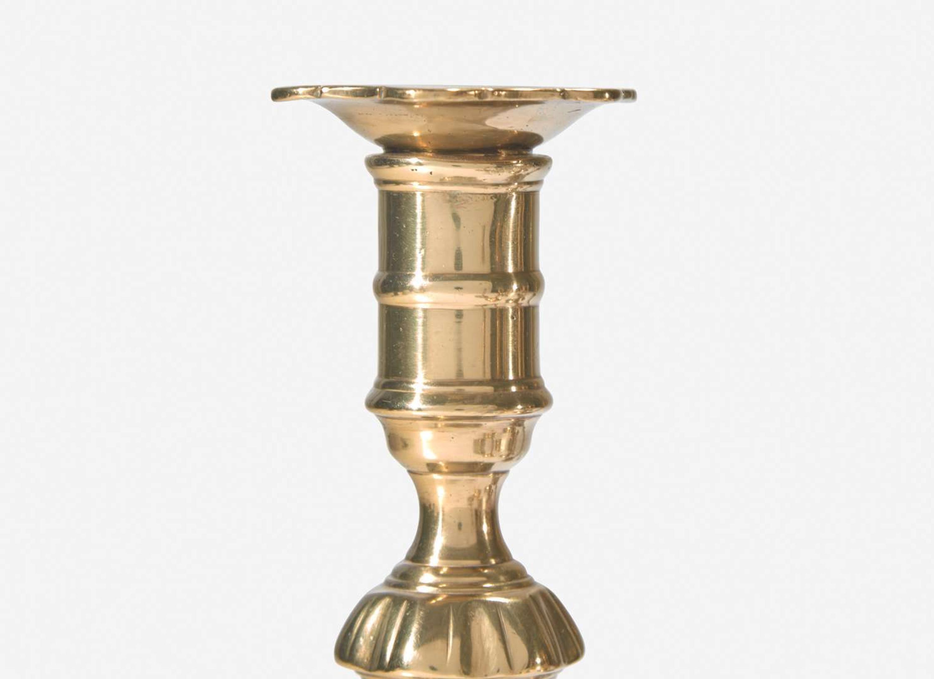 A group of ten George II scallop or petal-base brass candlesticks, England, 18th century