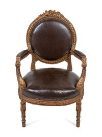 A Louis XVI Style Leather Upholstered and Parcel Gilt Fauteuil
