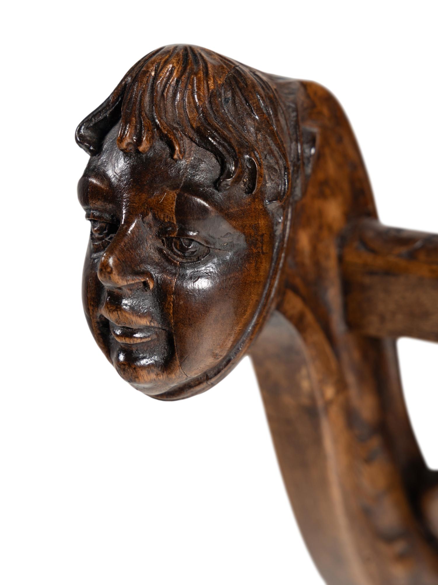 An Italian Renaissance Revival Carved Walnut Curule Bench