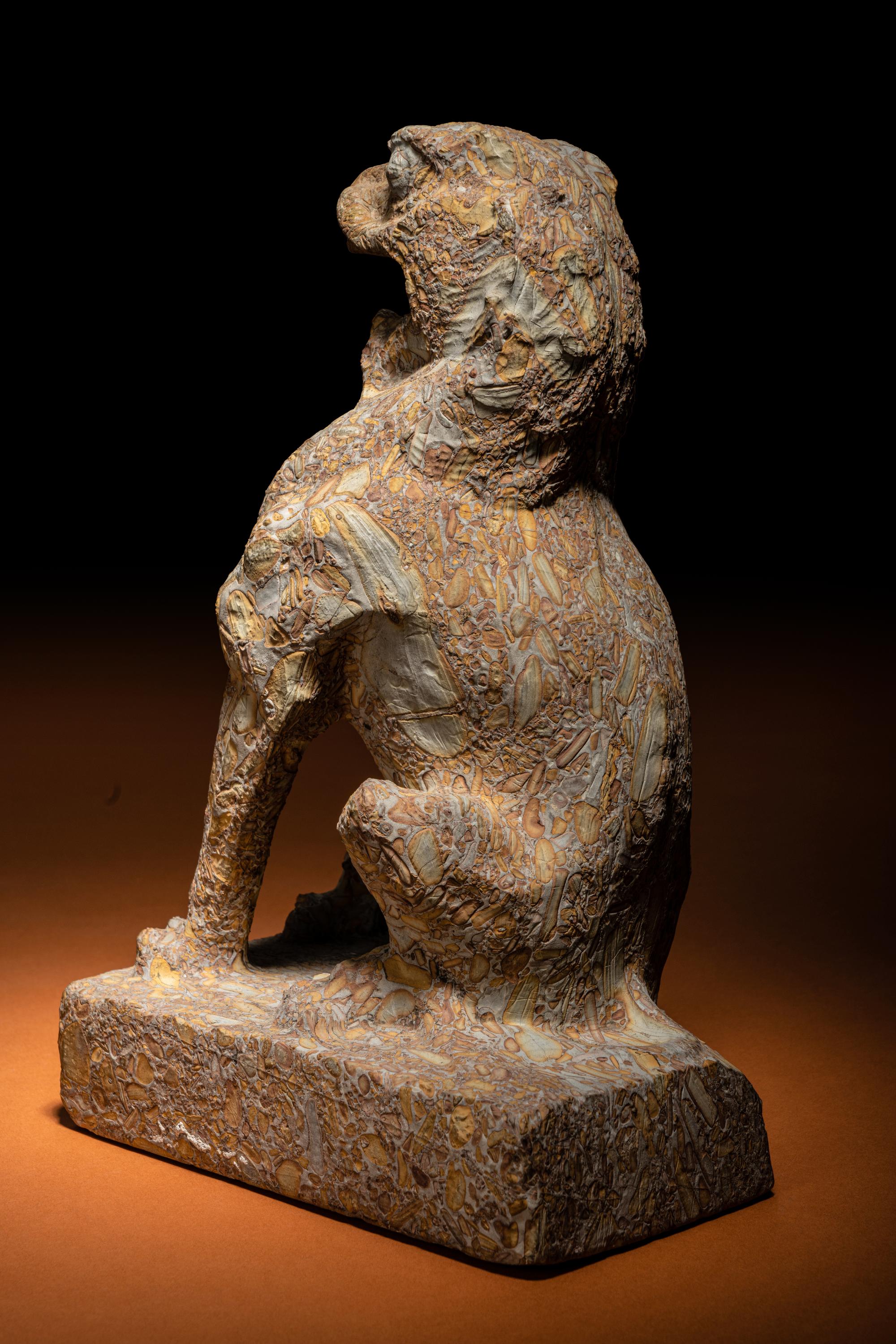 A Carved Puddingstone Figure of a Seated Lion