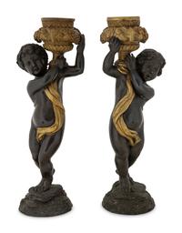 A Pair of Parcel Gilt Cast Metal Putti Candlesticks