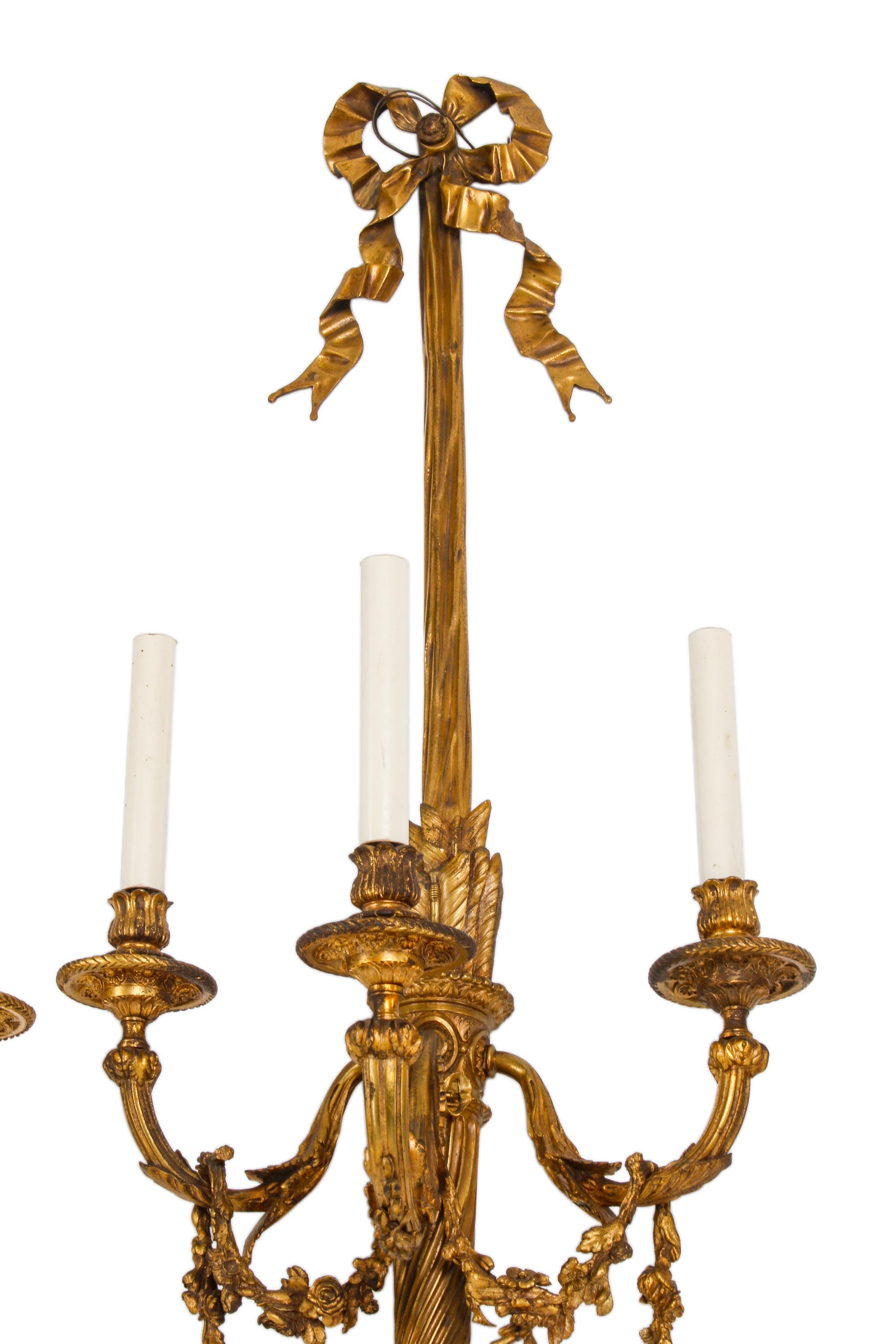 A Set of Four Louis XVI Style Gilt Bonze Three-Light Sconces