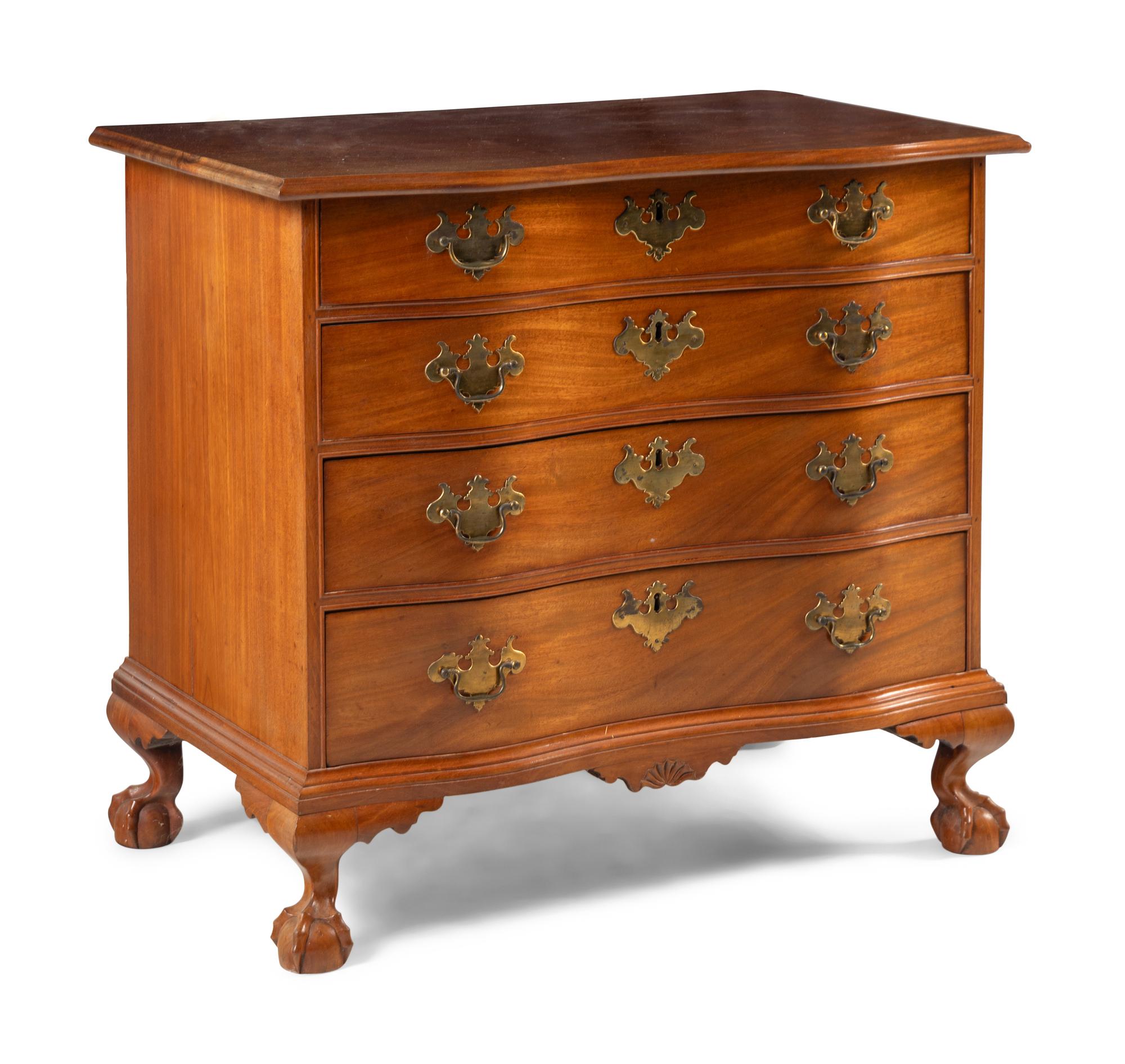 A Chippendale Carved And Figured Mahogany Serpentine Chest Of Drawers