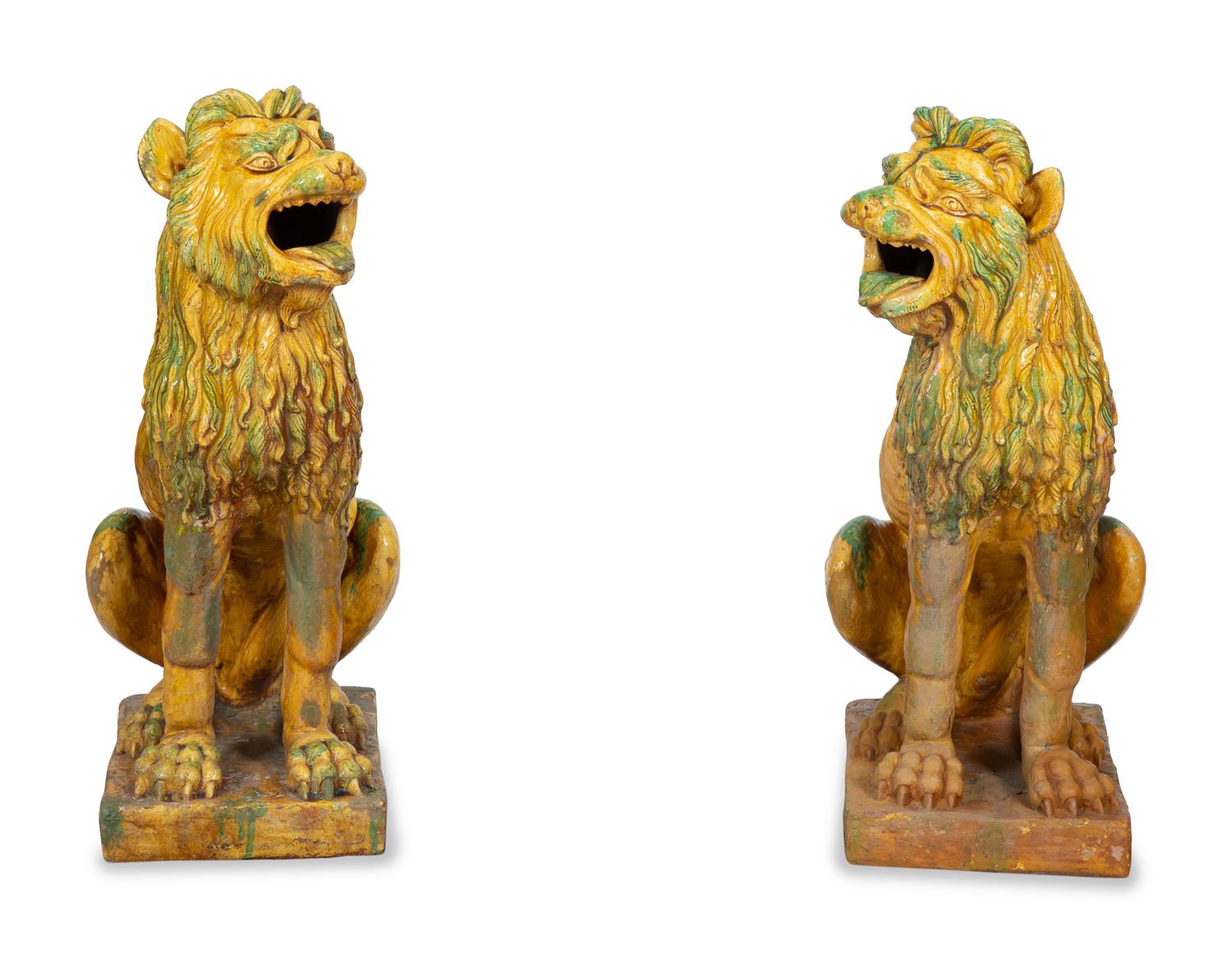 A Pair of Italian Yellow and Green Glazed Ceramic Figures of Seated Lions