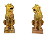 A Pair of Italian Yellow and Green Glazed Ceramic Figures of Seated Lions