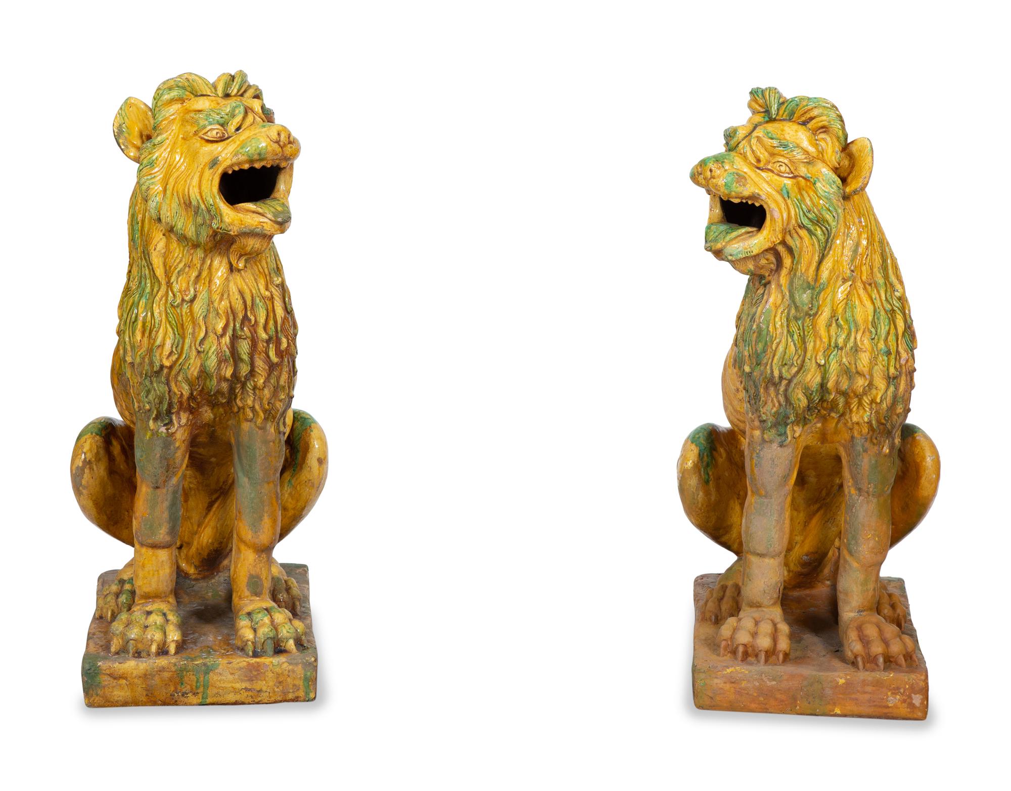 A Pair of Italian Yellow and Green Glazed Ceramic Figures of Seated Lions