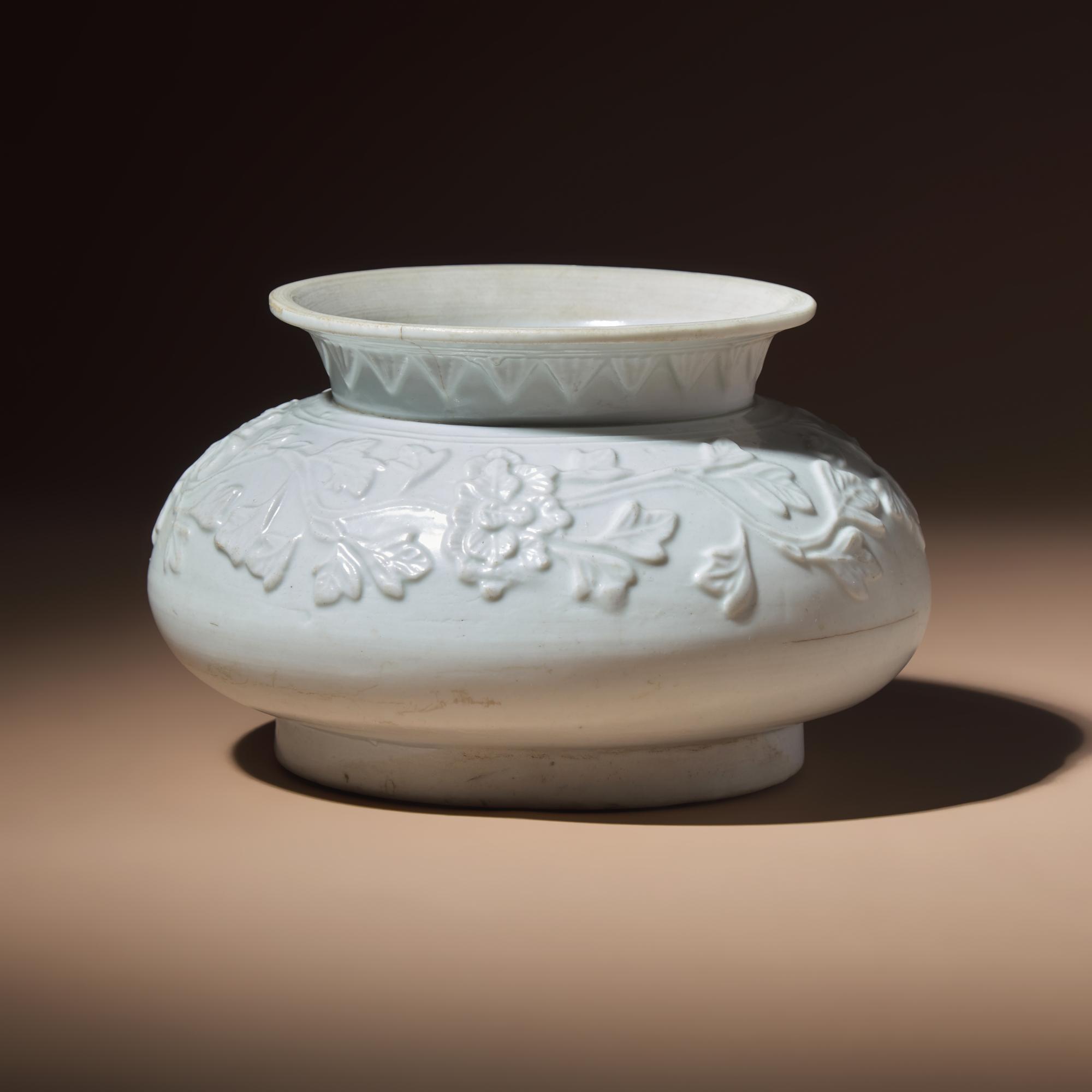 A Chinese White Glazed Molded Porcelain 'Floral' Jar, Mid Ming Dynasty, 15th Century — 明中期 白釉模印纏枝花卉敞口罐