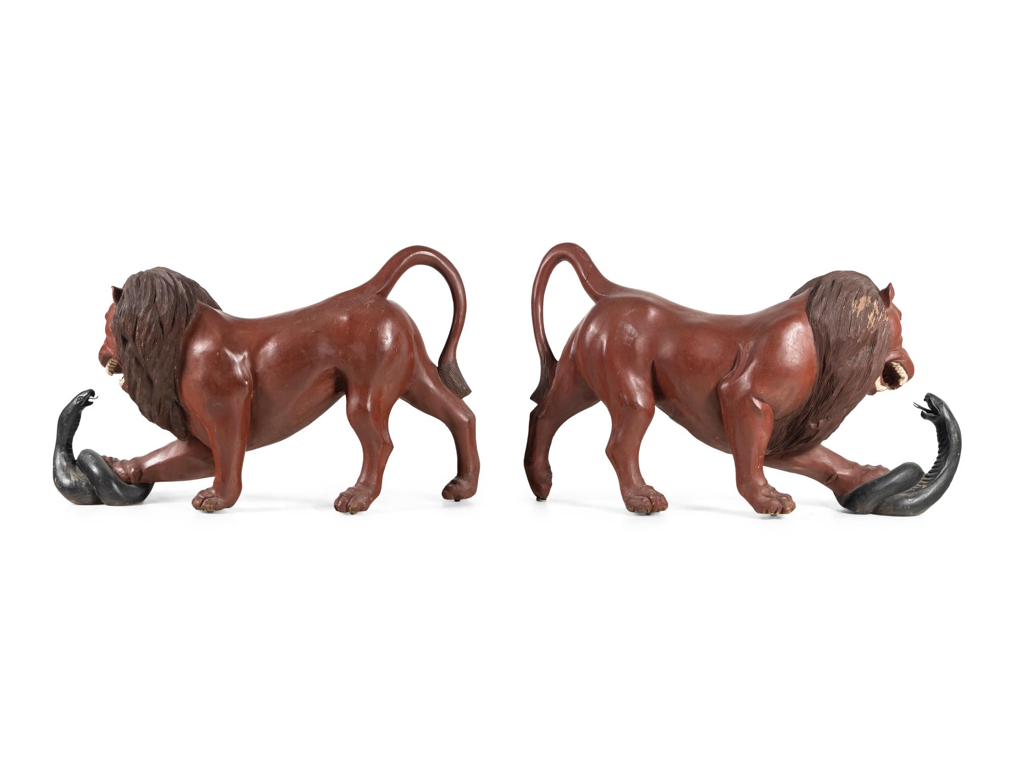 A Pair of Carved and Painted Wood Lions Wrestling Serpents
