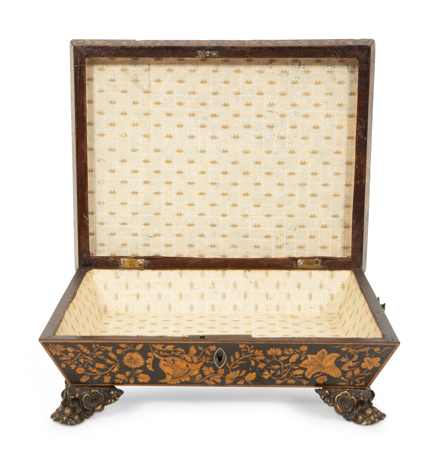 A Regency Black and Gilt Lacquer Box on Brass Paw Feet