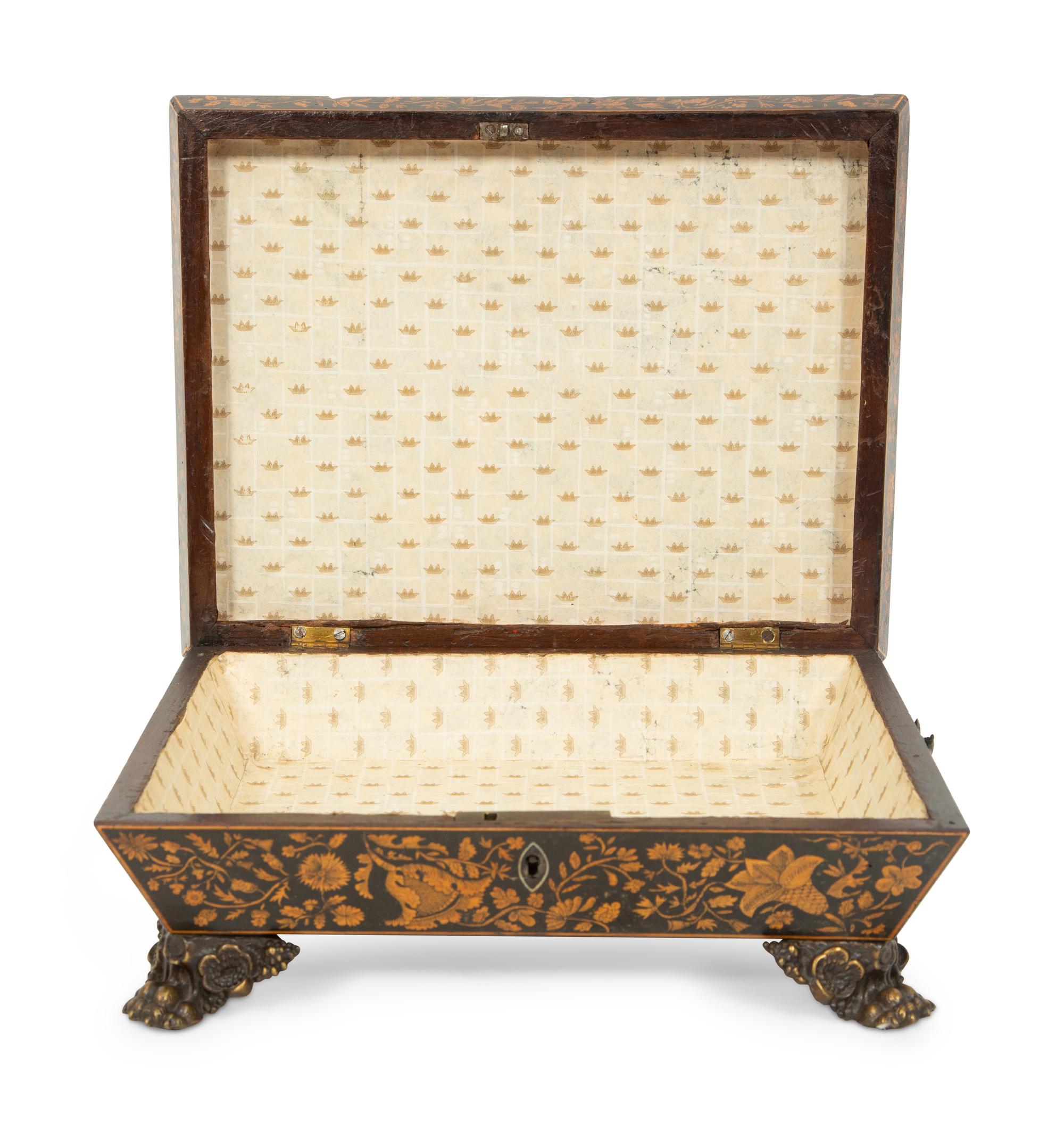 A Regency Black and Gilt Lacquer Box on Brass Paw Feet