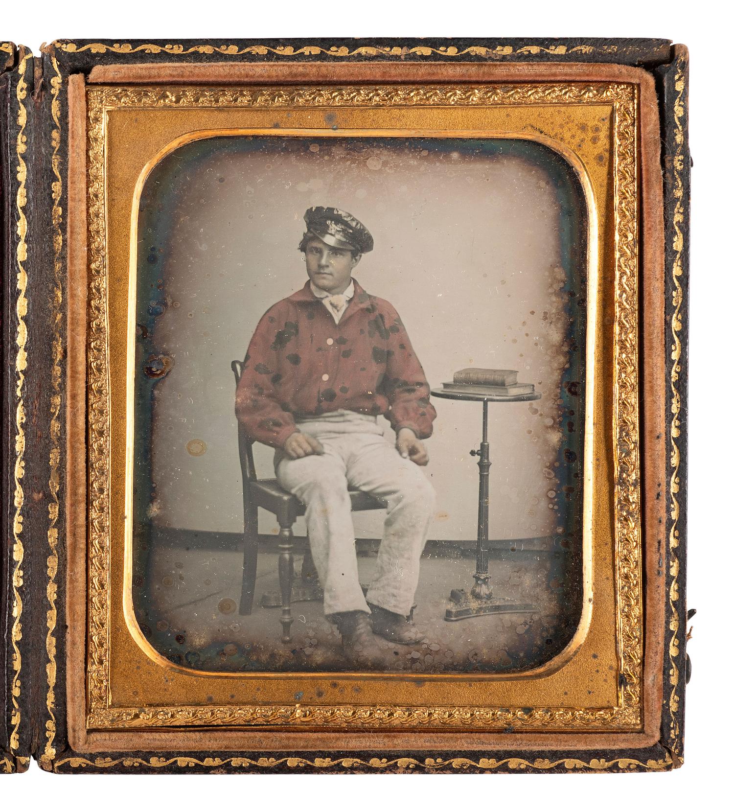 [EARLY PHOTOGRAPHY - MILITARIA]. Sixth plate daguerreotype of a possible fireman wearing a red-tinted jacket, possibly identified.