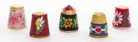 A Collection of Five Fabric Covered Metal Thimbles Height of tallest 3/4 inch.