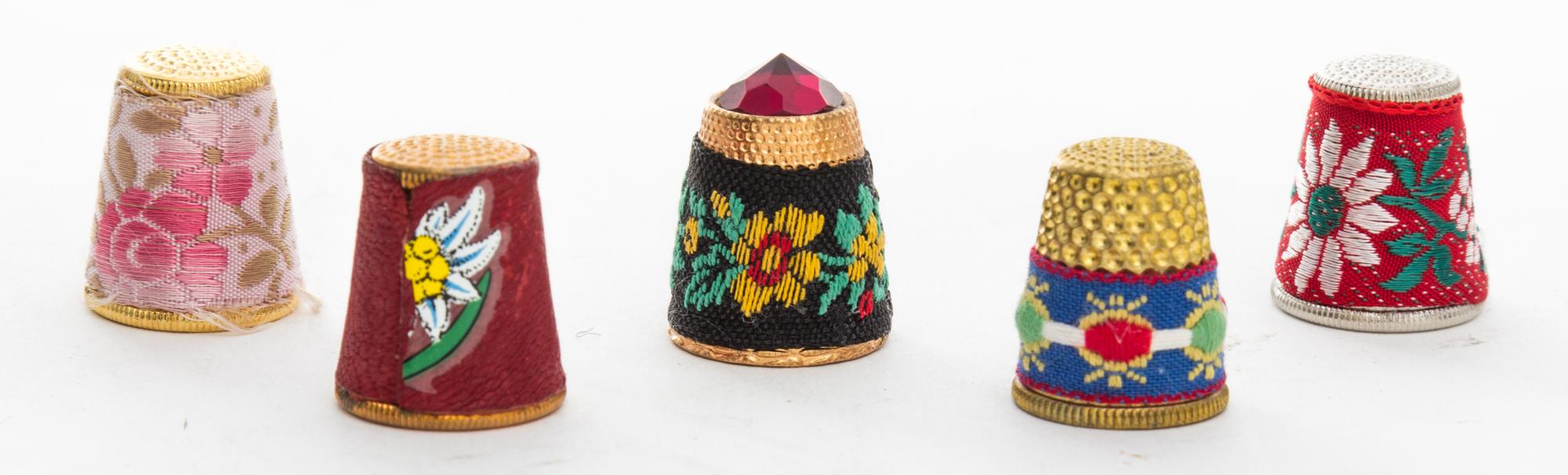 A Collection of Five Fabric Covered Metal Thimbles Height of tallest 3/4 inch.