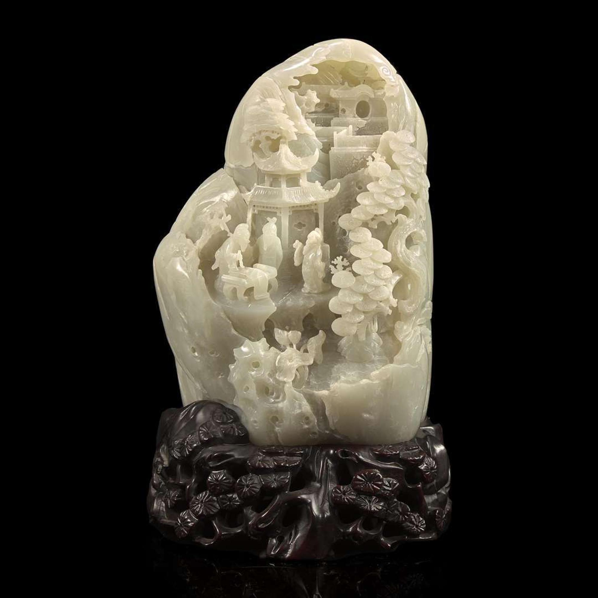 A Chinese carved greyish-white jade "Mountain" and carved wood stand 灰白玉山子及木底座 20th century ????