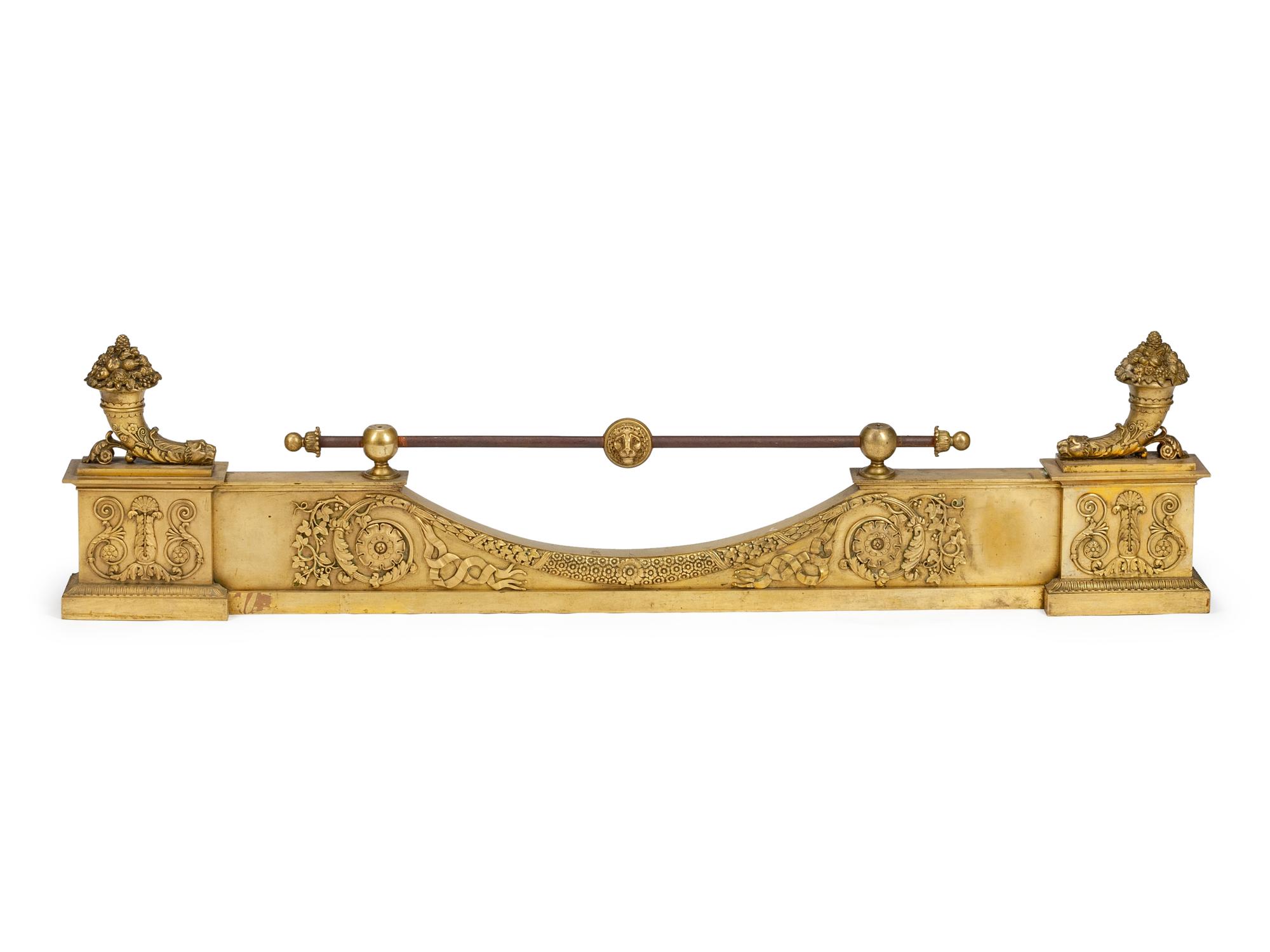 A Pair of Empire Gilt Bronze Chenets and a Fireplace Fender