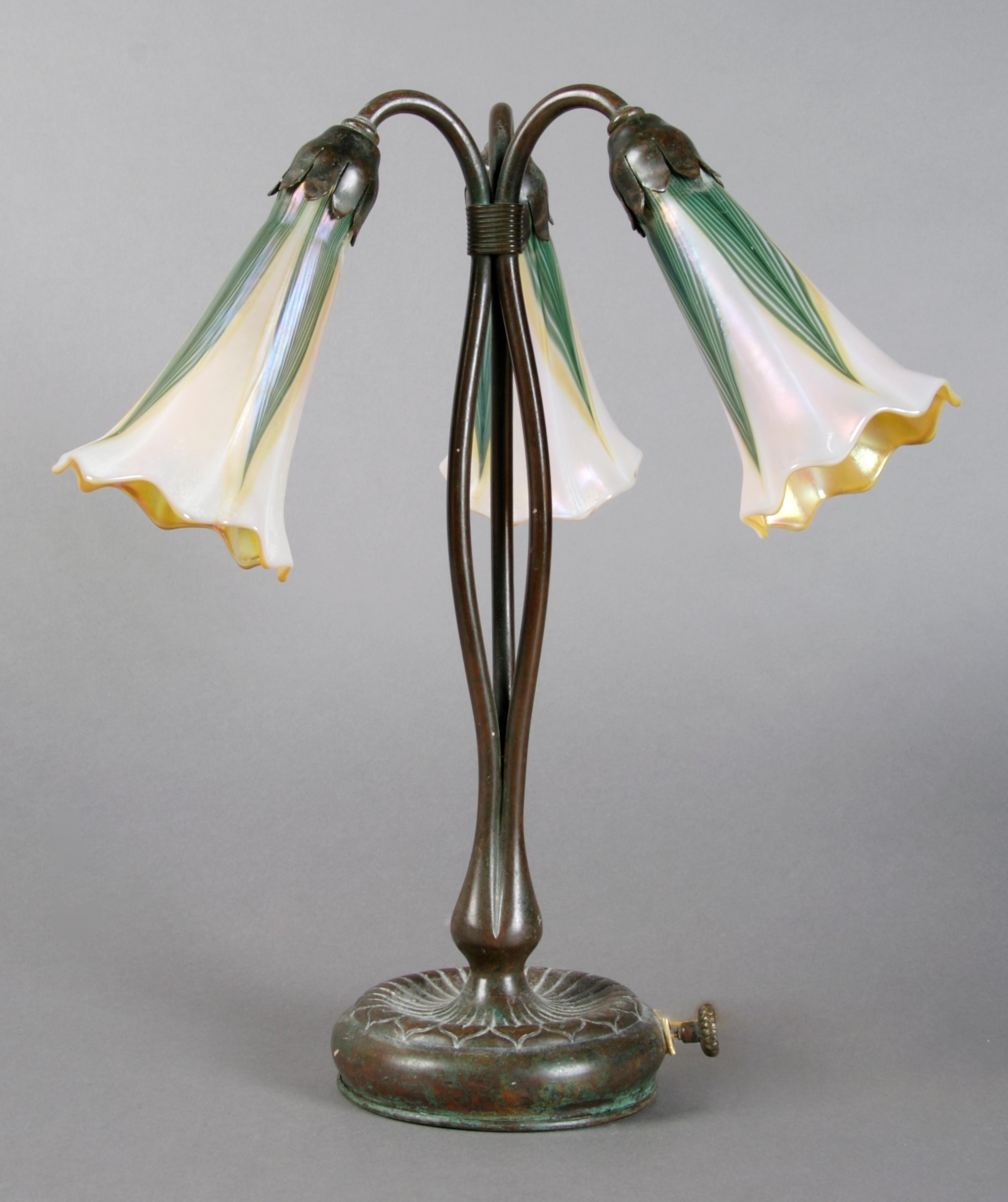 A Tiffany Studios Bronze Three-Light Lily Lamp, Height 13 inches.