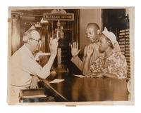[SPORTS]. Press photo of Jesse Owens and Minnie Ruth Solomon applying for a marriage license, 1935.