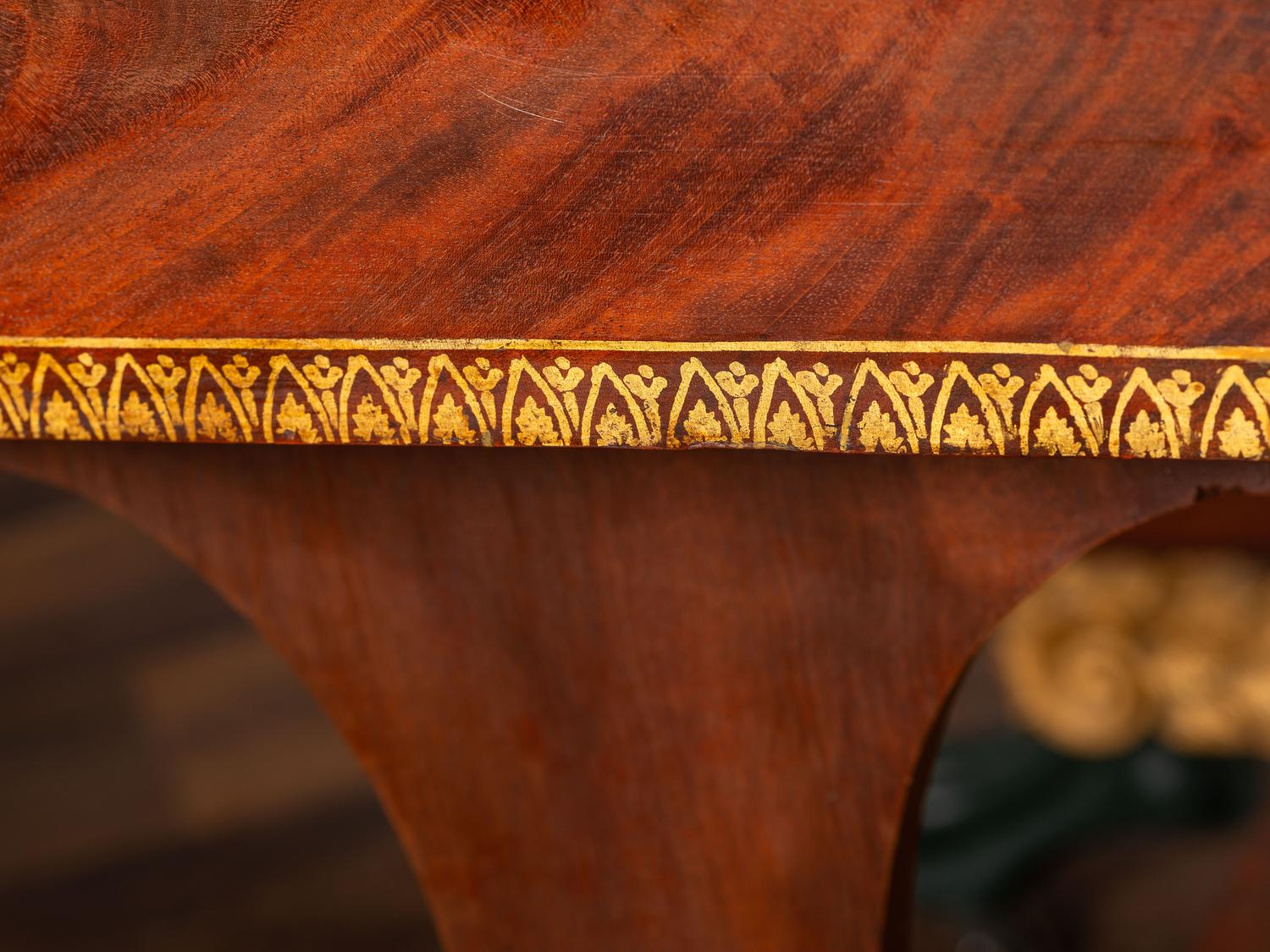 A Classical Parcel Gilt and Ebonized, Figured Mahogany Paw-Foot Drop-Leaf Table
