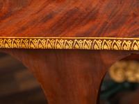 A Classical Parcel Gilt and Ebonized, Figured Mahogany Paw-Foot Drop-Leaf Table
