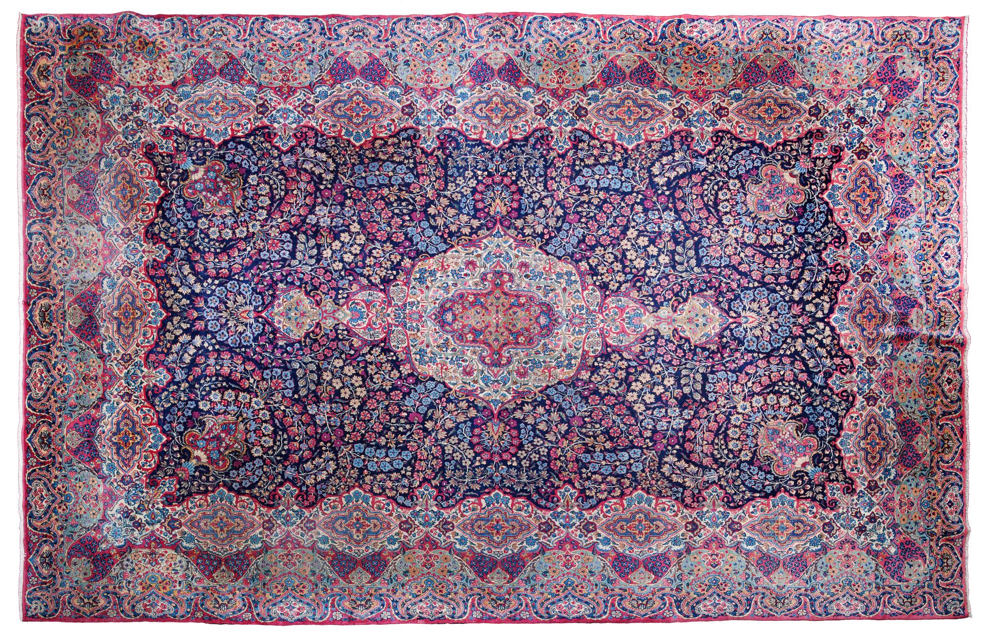 A Kirman Carpet 13 feet 11 inches x 9 feet 9 1/2 inches.
