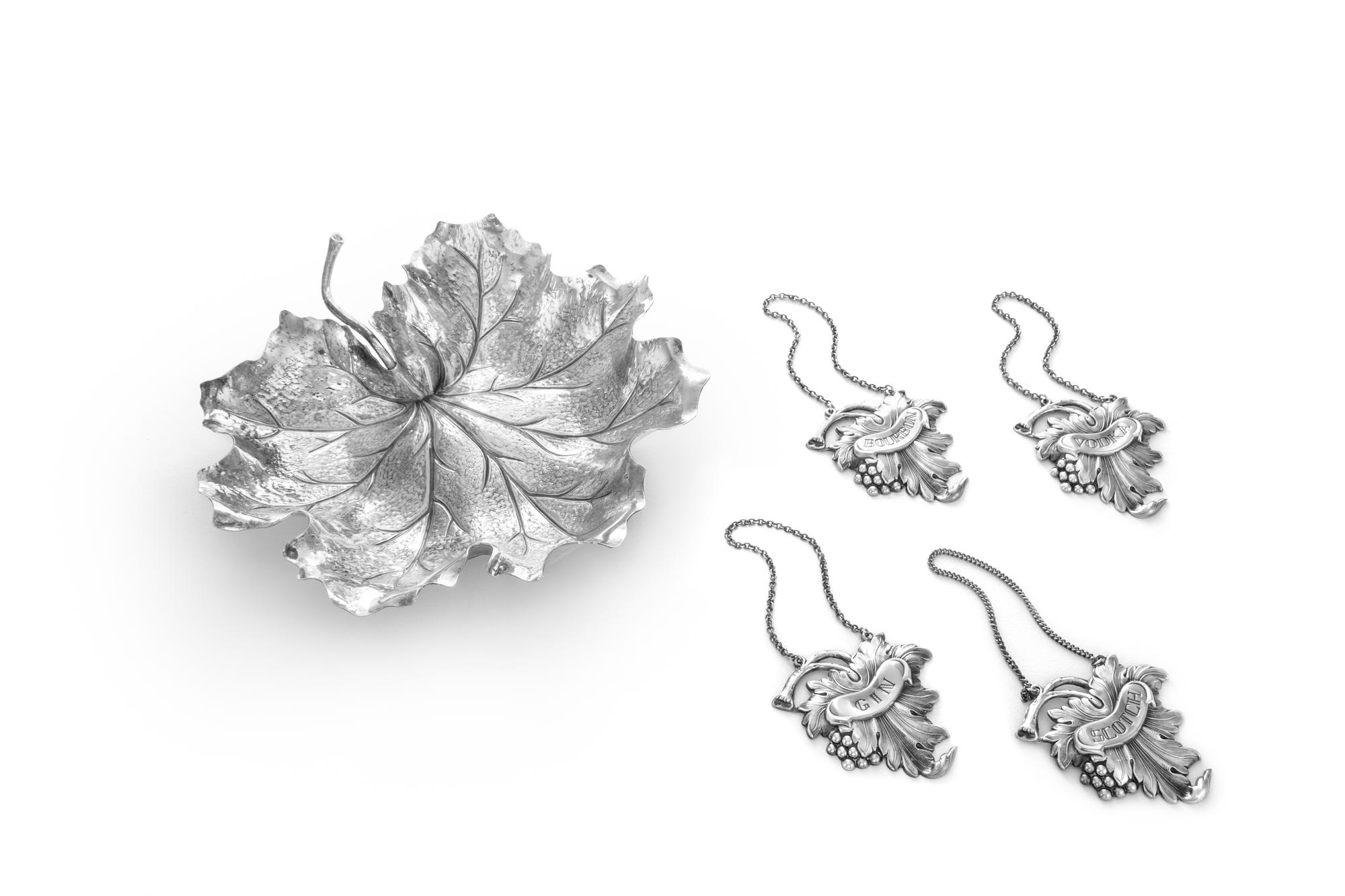 An Italian Silver Dish, Buccellati, Milan, Second Half 20th Century, in the form of a leaf, together with four silver-plate liquor tags