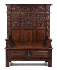 A Gothic Revival Carved Oak Hall Bench, Height 69 1/4 x width 52 1/4 x depth 21 inches.