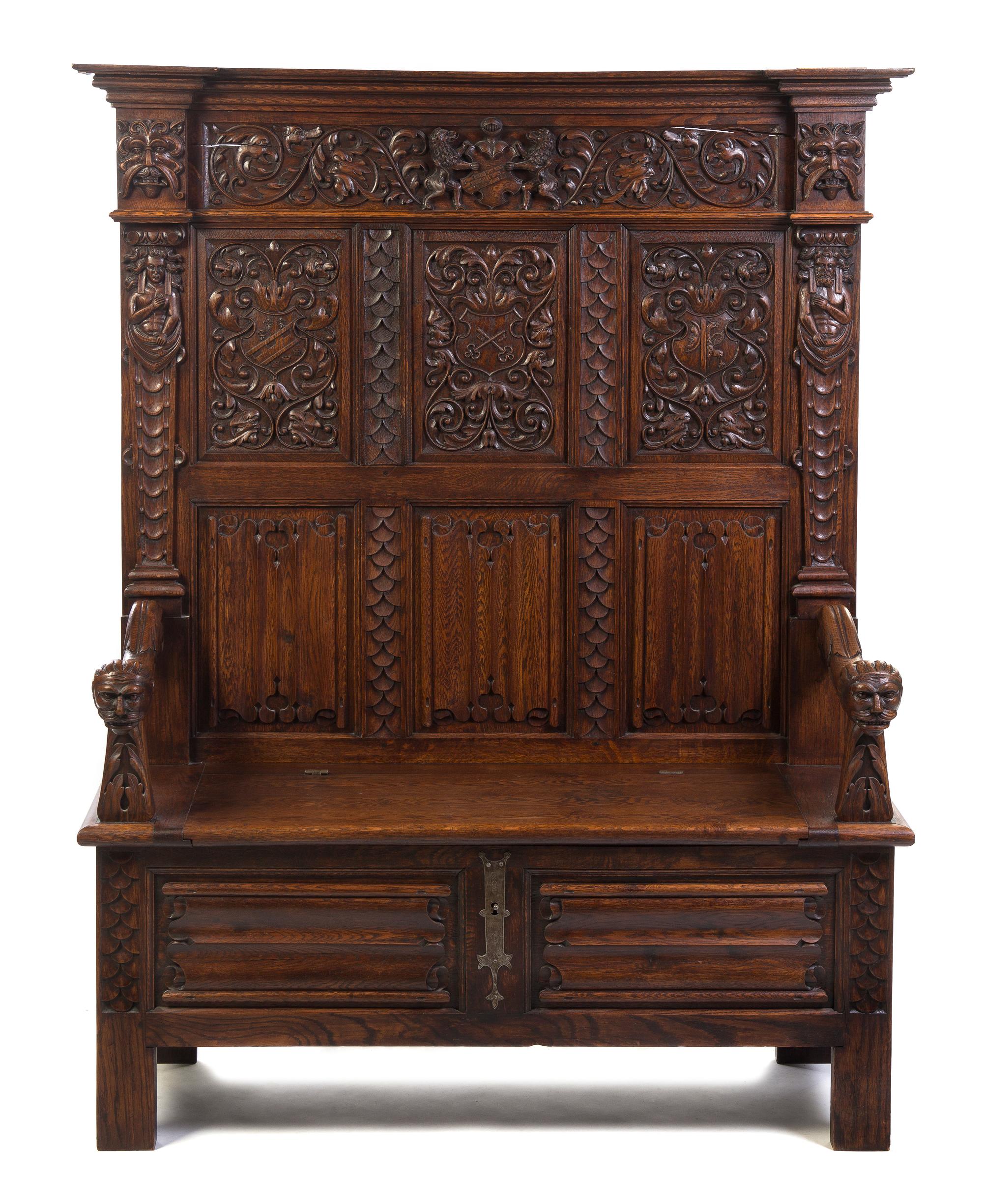 A Gothic Revival Carved Oak Hall Bench, Height 69 1/4 x width 52 1/4 x depth 21 inches.