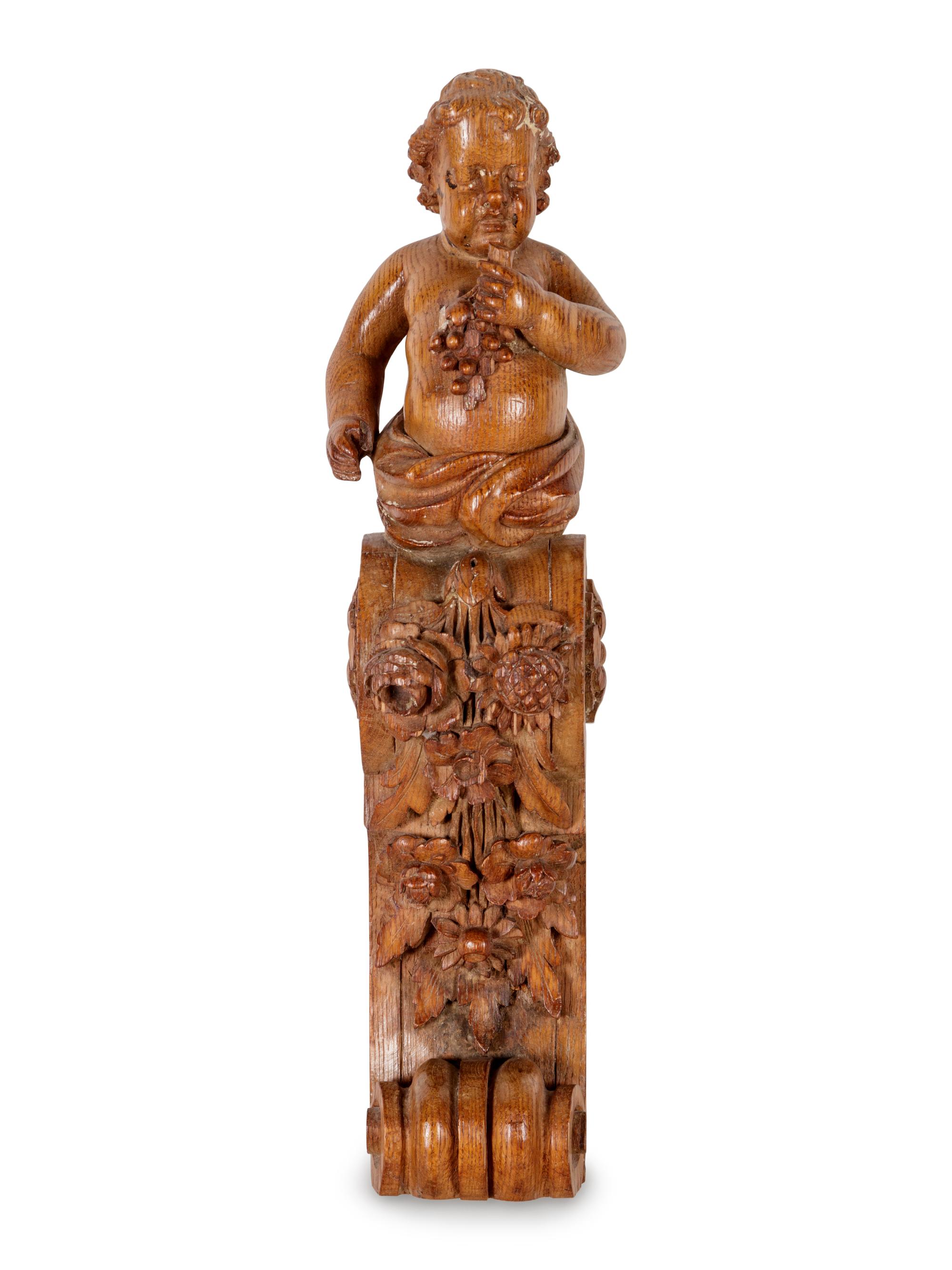 A Continental Carved Oak Figural Bracket in the Form of a Putto