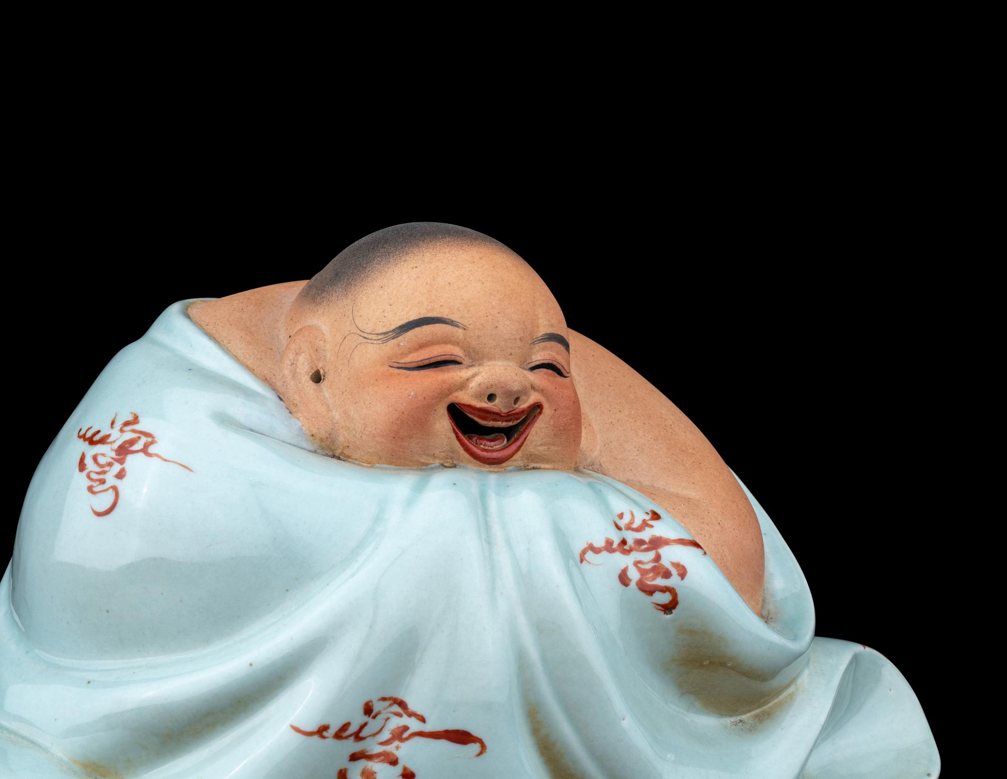 A Celadon Glazed Porcelain Figure of a Budai Buddha