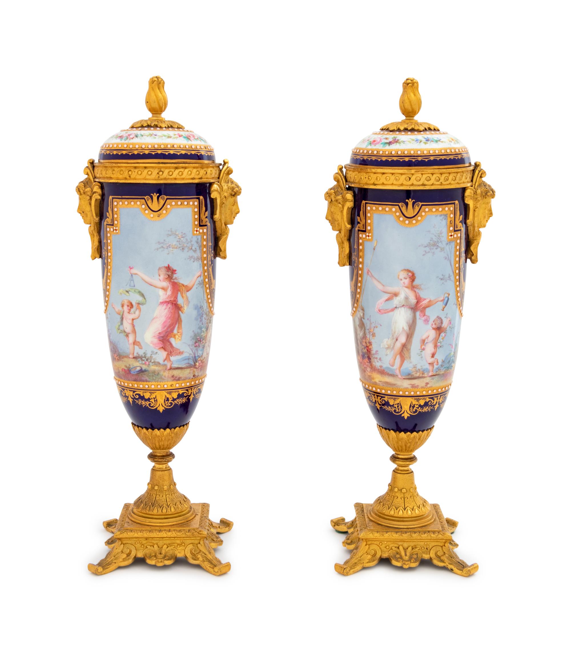 A Pair of Sèvres Style Gilt Bronze Mounted Painted, Parcel Gilt and "Jeweled" Porcelain Urns