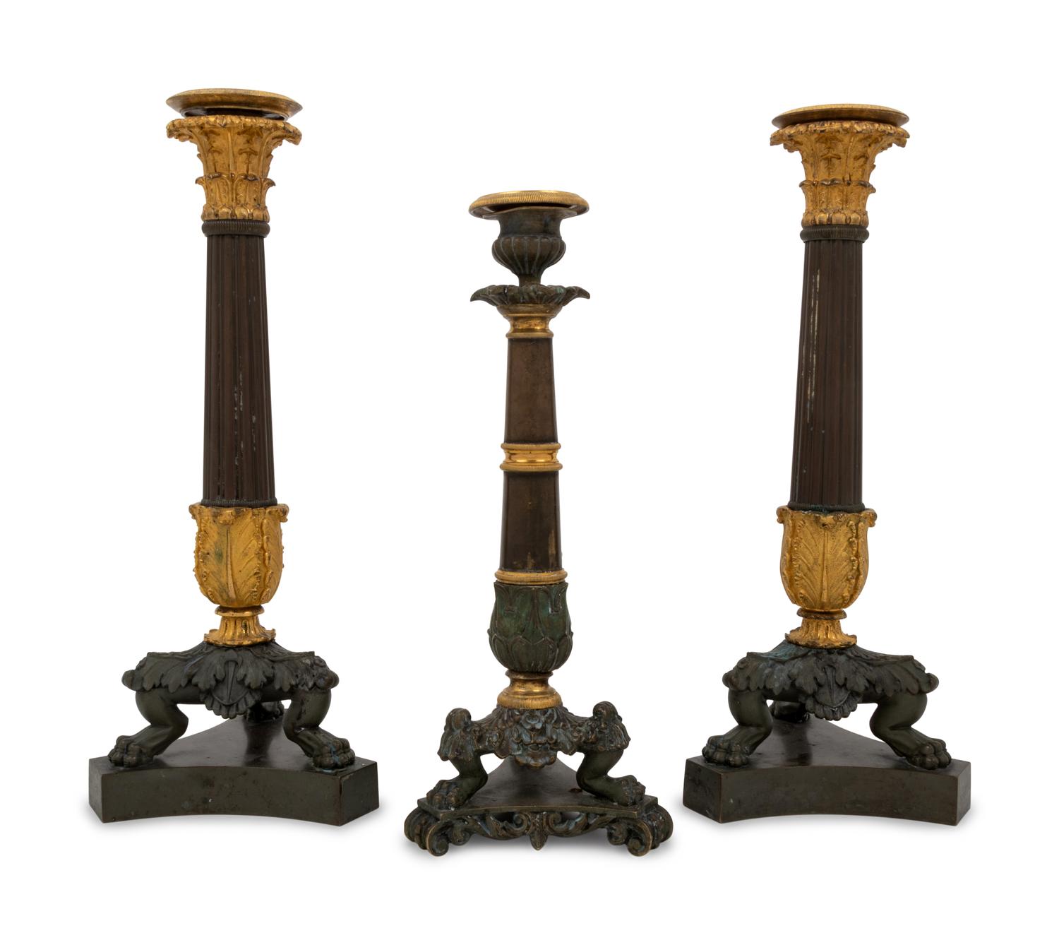 A Pair of Neoclassical Gilt Bronze Candlesticks and a Similar Candlestick