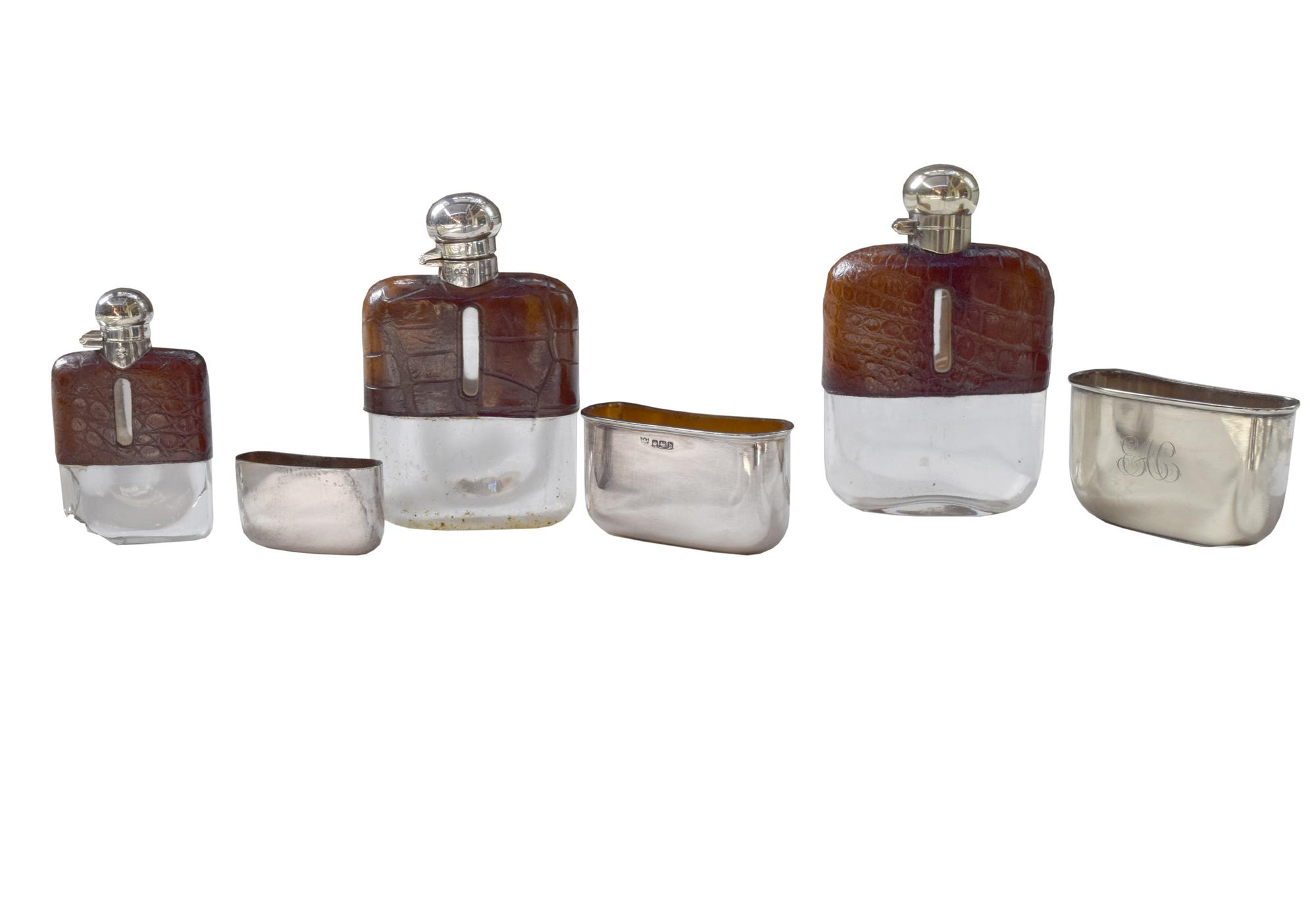 A Set of Three Silver and Stamped Leather Hip Flasks Left: 2.25" x .5" x 3.75" tall: Middle: 3" x 1" x 5" tall: Right: 3.25" x 1" x 5.5 — England, Circa 1925-1940