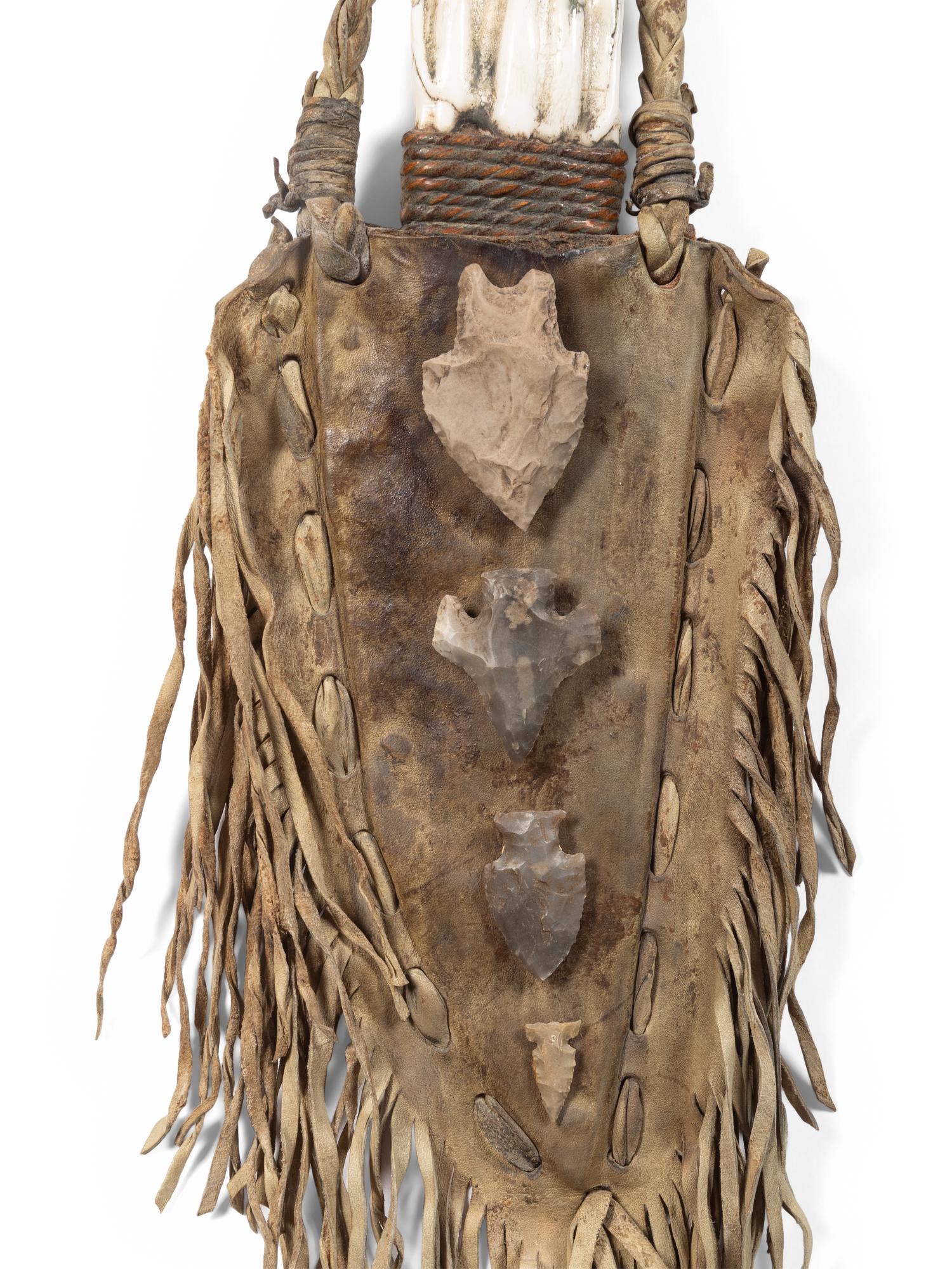 A Fringed Leather or Hide Bag with Attached Arrowheads